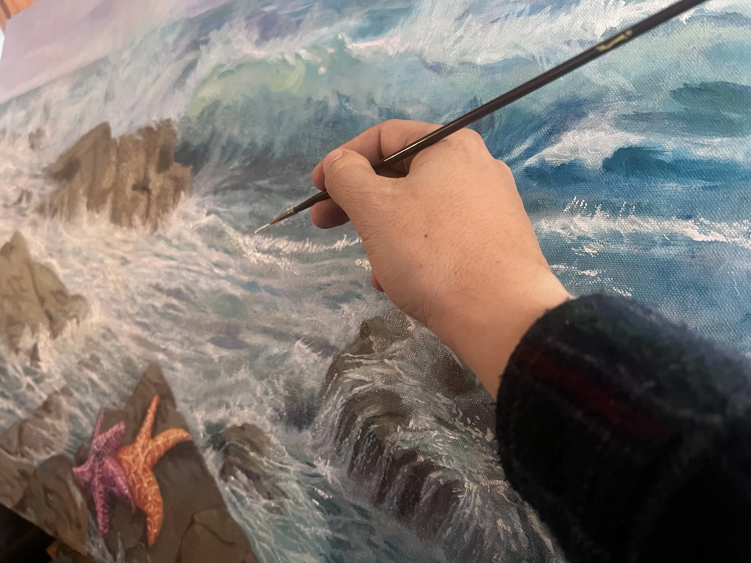 Oil paintin of the ocean with two Sea Stars by the seashore.