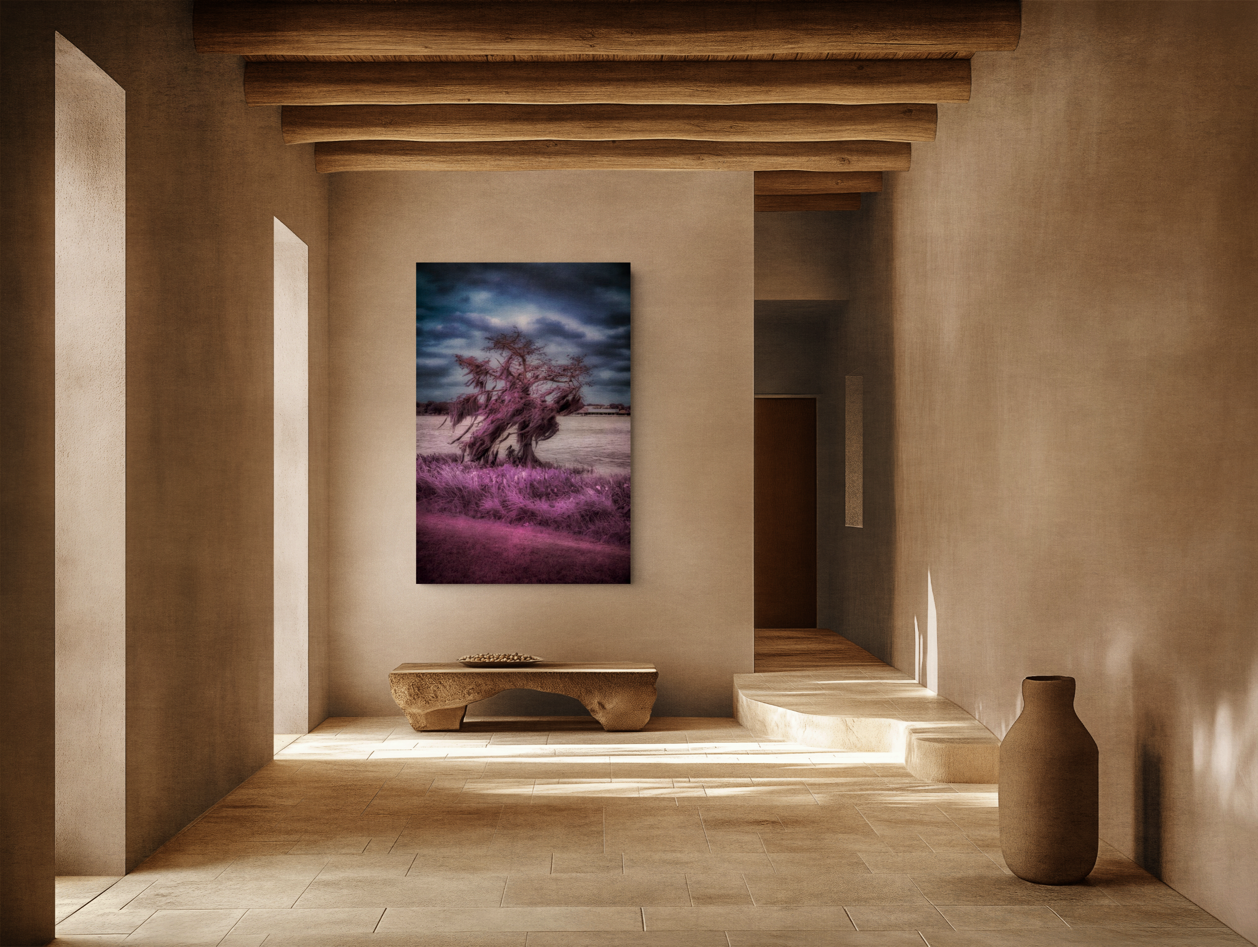 A minimalist interior with wooden beams on the ceiling, soft beige walls, and a landscape painting featuring a tree with pink leaves. There is a carved wooden bench and a large pottery vase on the right.