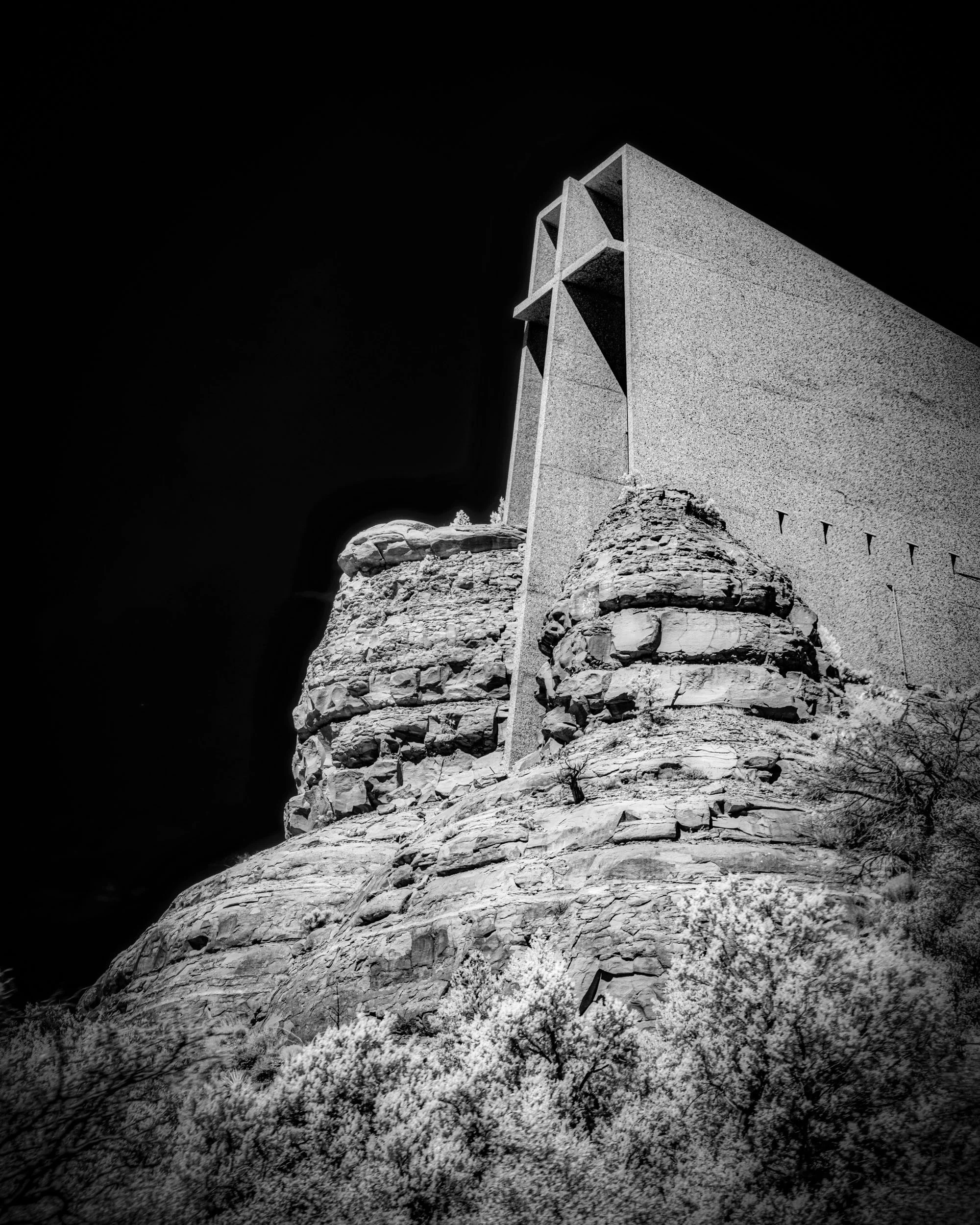 Sacred Lines in Rocky Silence — The Church of the Holy Cross rises in sharp angular lines from Sedona's rugged cliffs, rendered in infrared black and white.