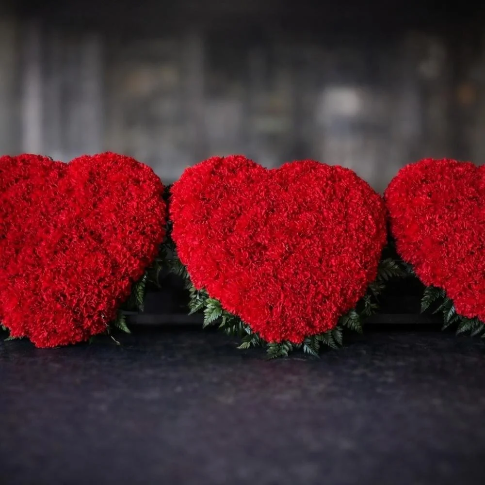 Funeral tribute design in a heart shape with red roses