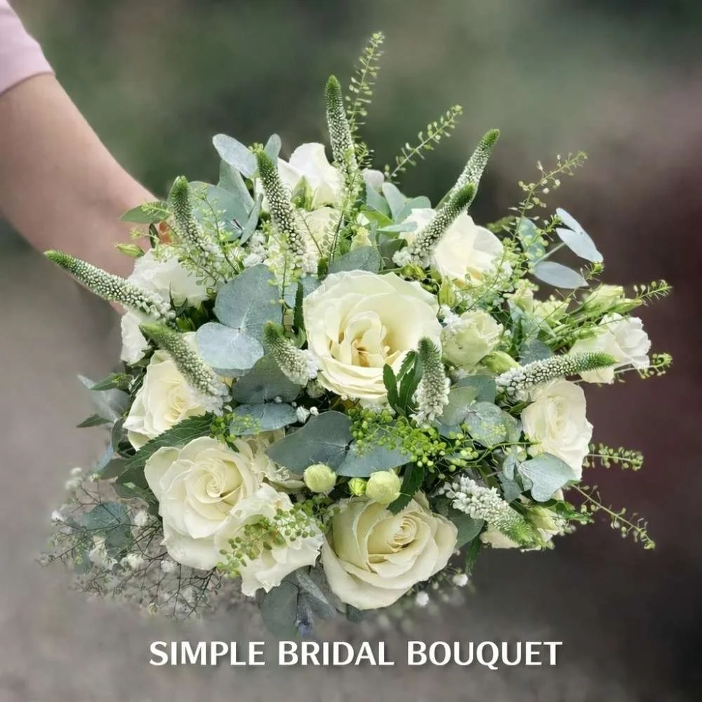 Simple bridal bouquet with white roses, soft greenery and natural foliage, handcrafted by Pasha Flowers