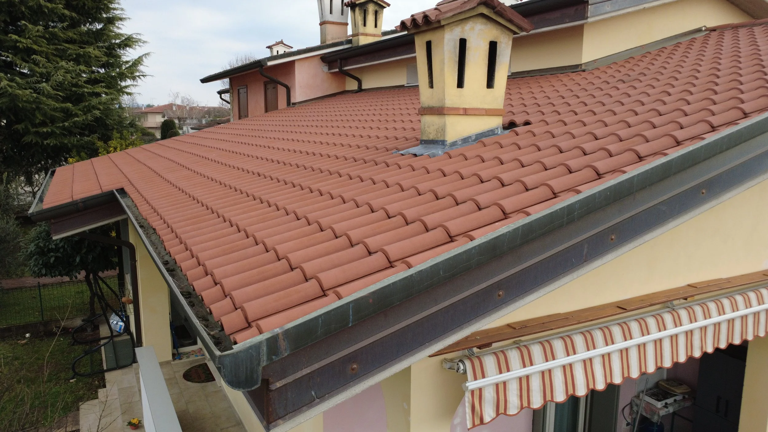 Ispezione aerea con drone di un tetto in tegole portoghesi per verifica integrità e pulizia grondaie