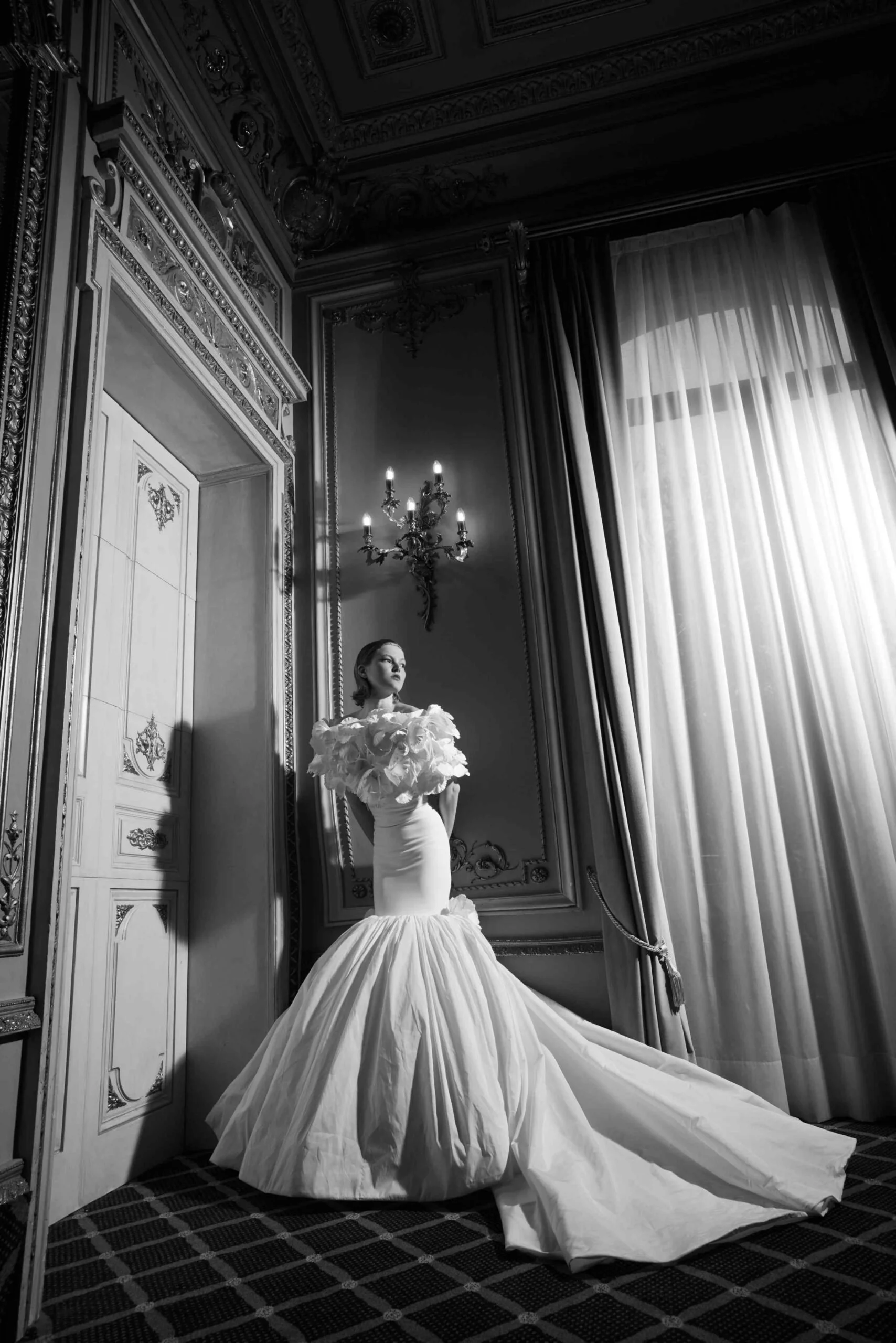 Abby Dress - Strapless gown in double crêpe with a puffed taffeta skirt and low hip cut. Overskirt in taffeta adorned with handcrafted flowers. Floral shrug sold separately.