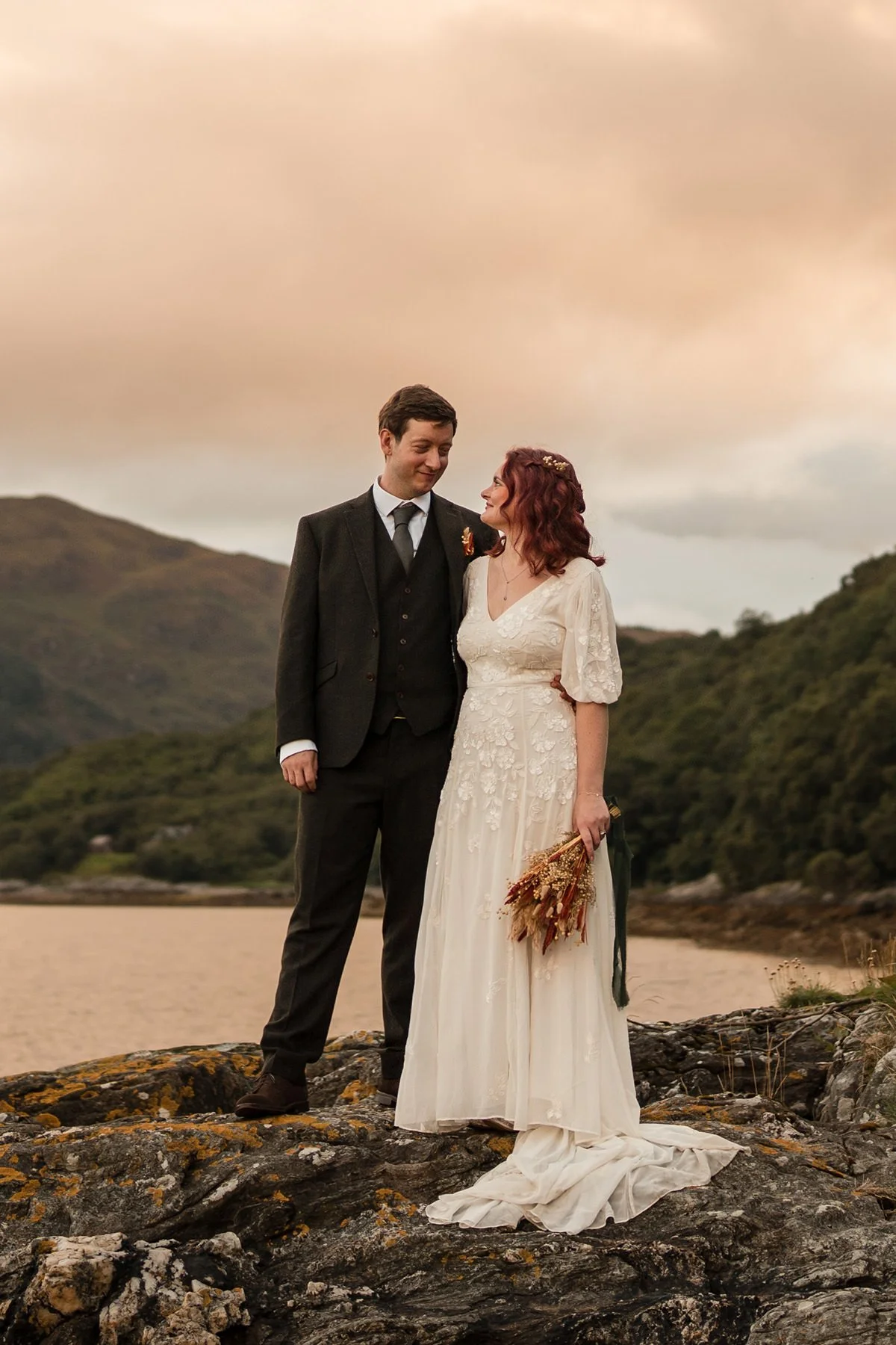 Bride and groom standing together on the coastline during a romantic Dunoon elopement, photographed by Scotland wedding and elopement photographer Andy Hamilton.