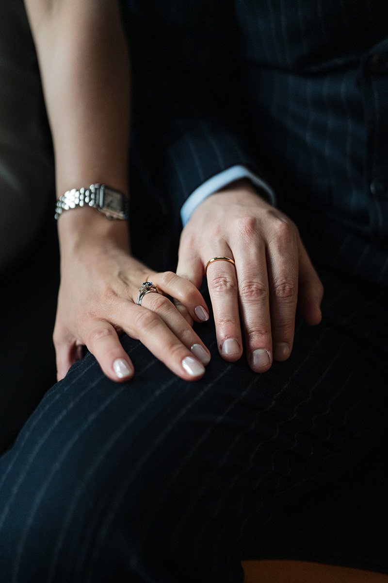 Close-up of newly married couple holding hands showing their wedding rings