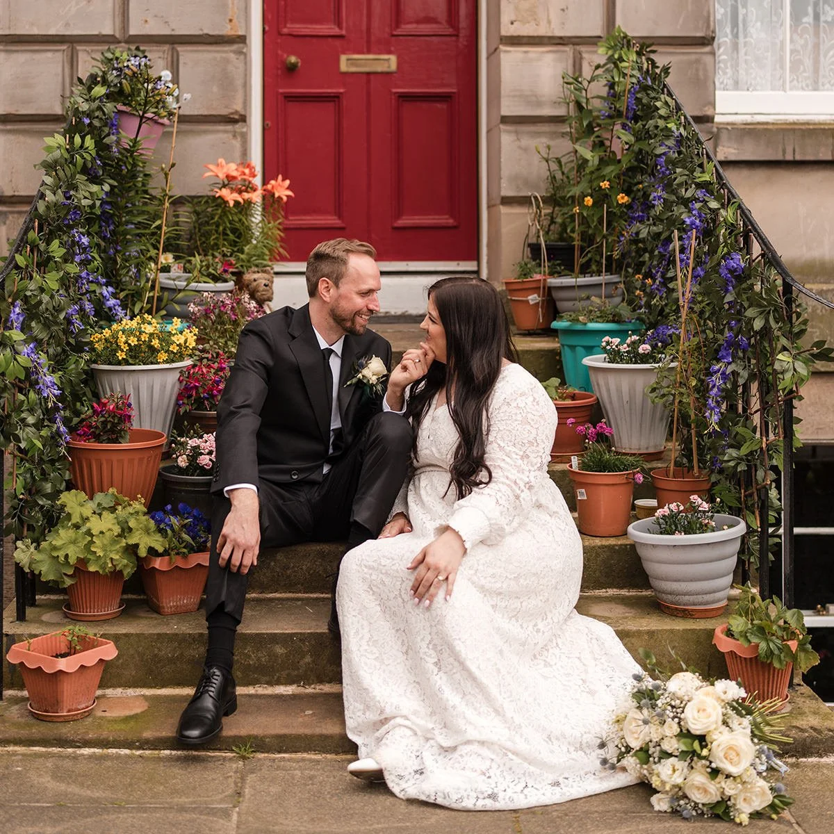 Couple sitting together on stone steps during an intimate elopement in Edinburgh
