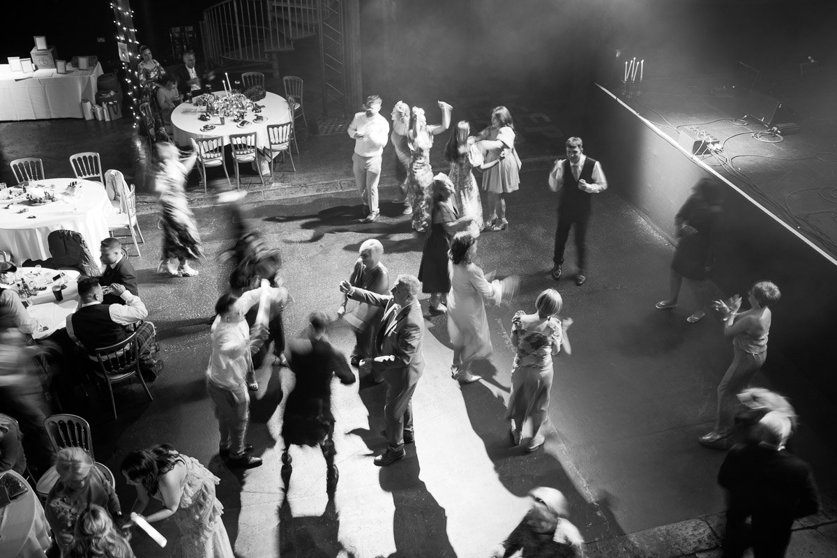 People dancing on a dance floor at a wedding with tables and chairs set up nearby, some guests seated and others dancing or socialising at Fruit Market, Glasgow