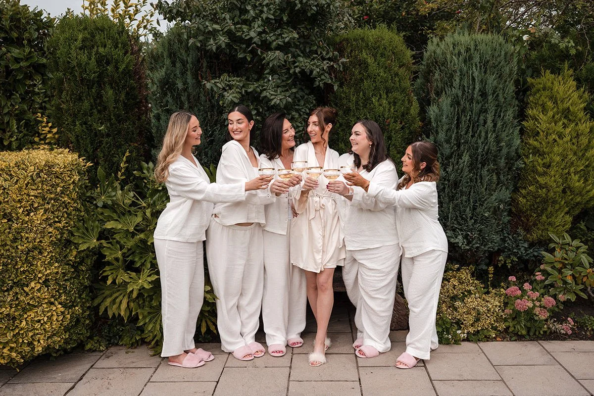 Bride and bridesmaids clinking champagne glasses during relaxed bridal prep on the wedding morning, photographed by a Scottish wedding photographer