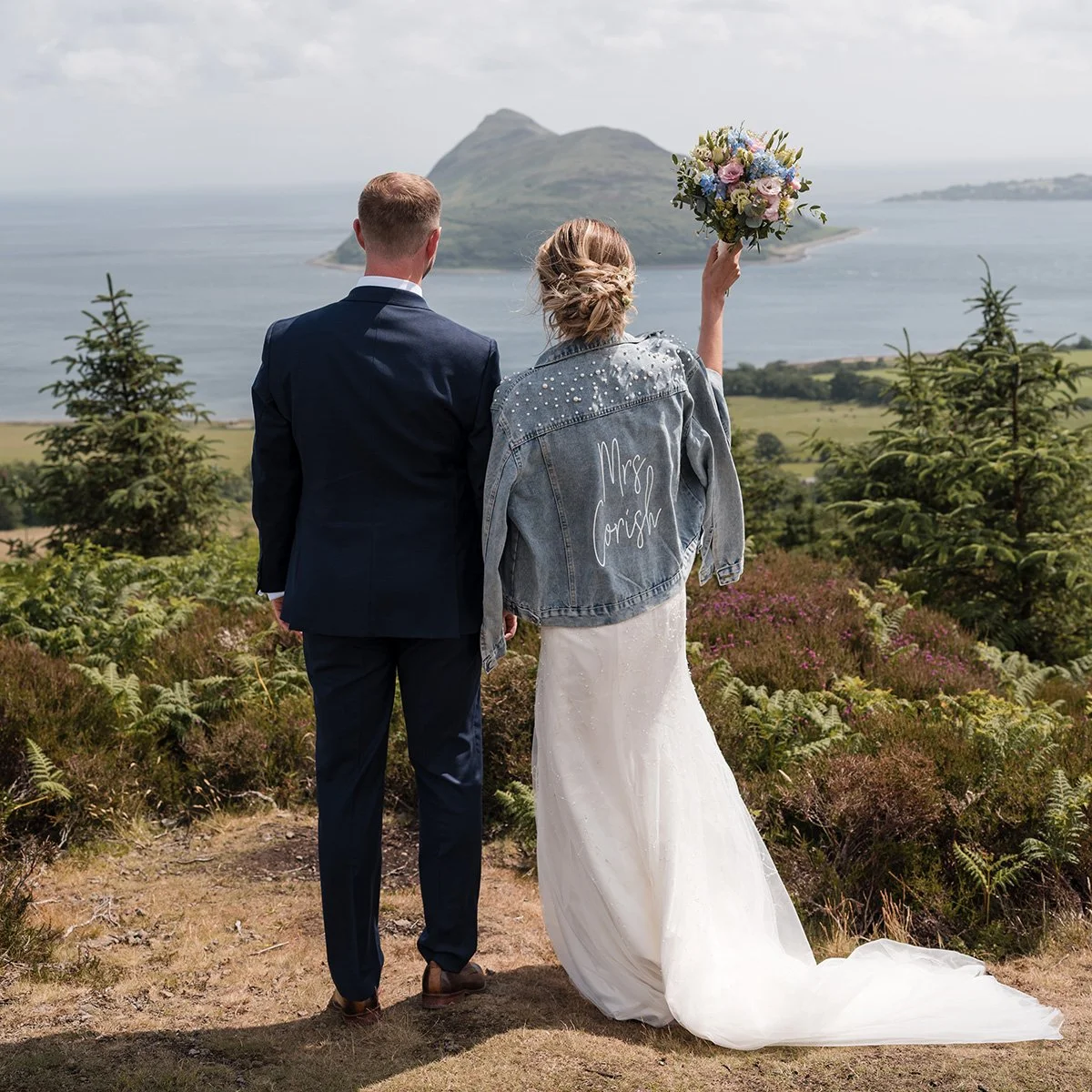 Couple standing together during an elopement on the Isle of Arran, overlooking the sea and coastline