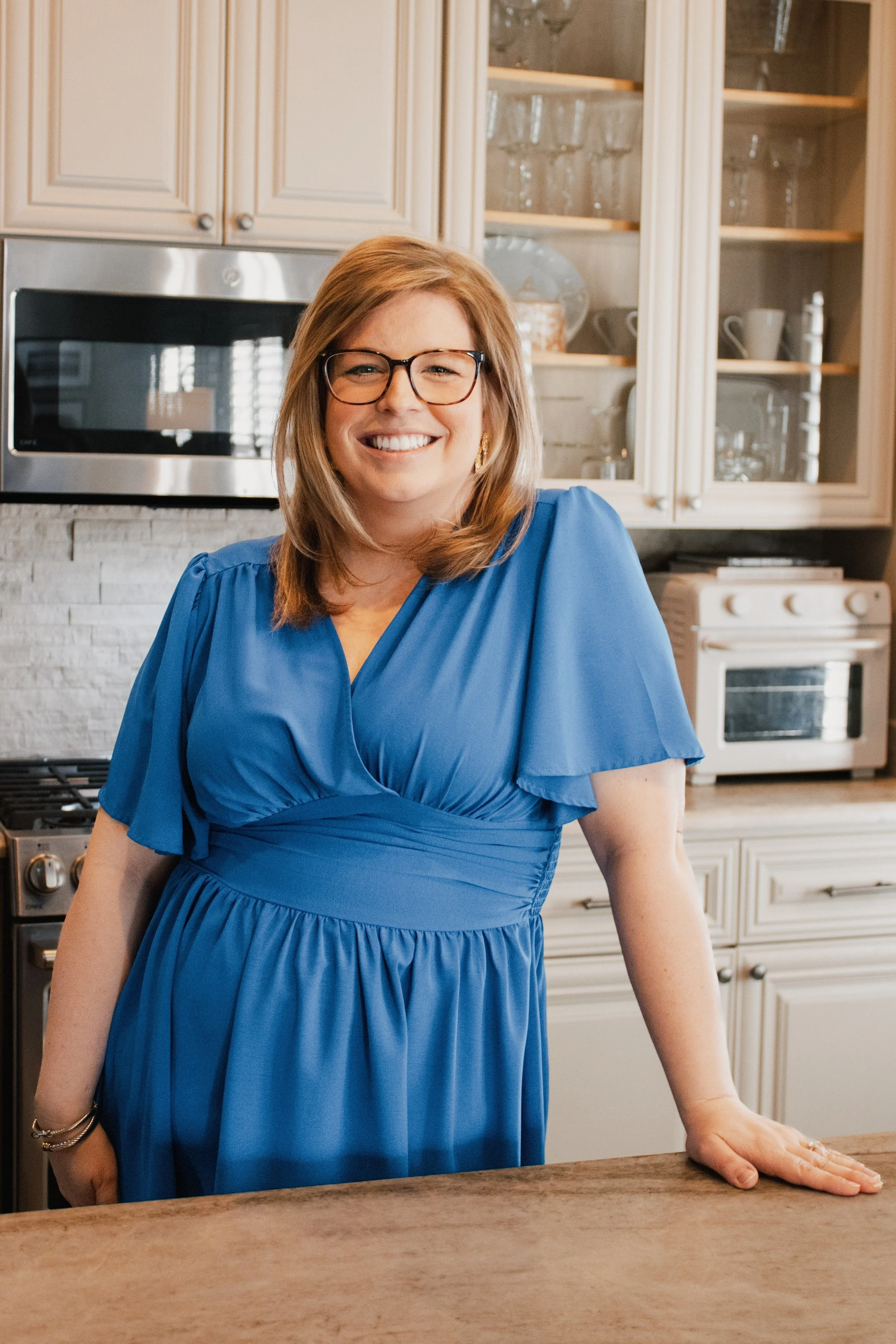 Allison Vega standing in a kitchen, A headshot of Allison Vega, Murfreesboro & Middle TN Real Estate Expert