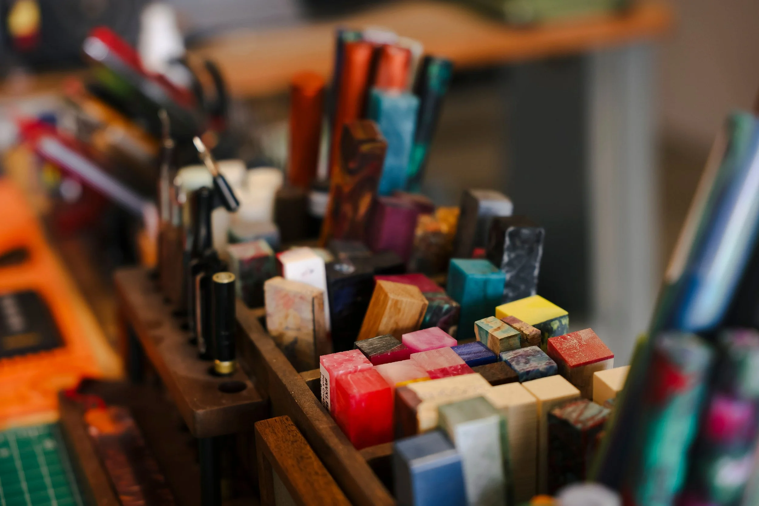 Assorted artist oils and pastels on a wooden tray.