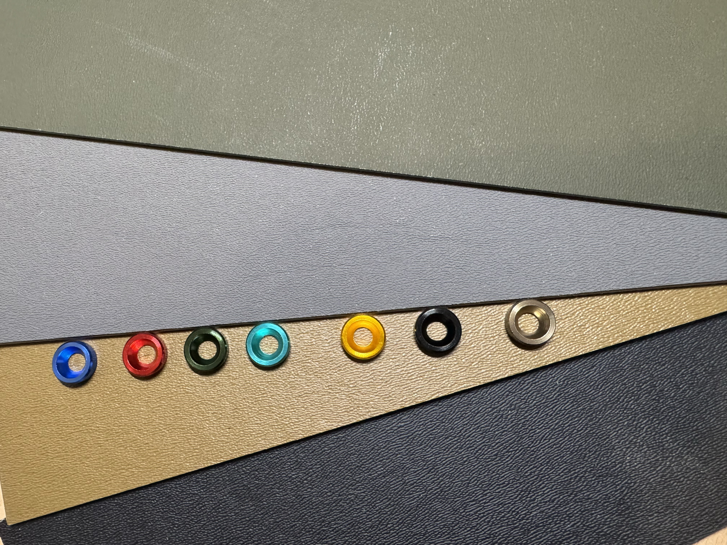 Colorful washer accents objects at the bottom, including red, green, blue, yellow, black, and silver. Holster additions to fully customize your next holster