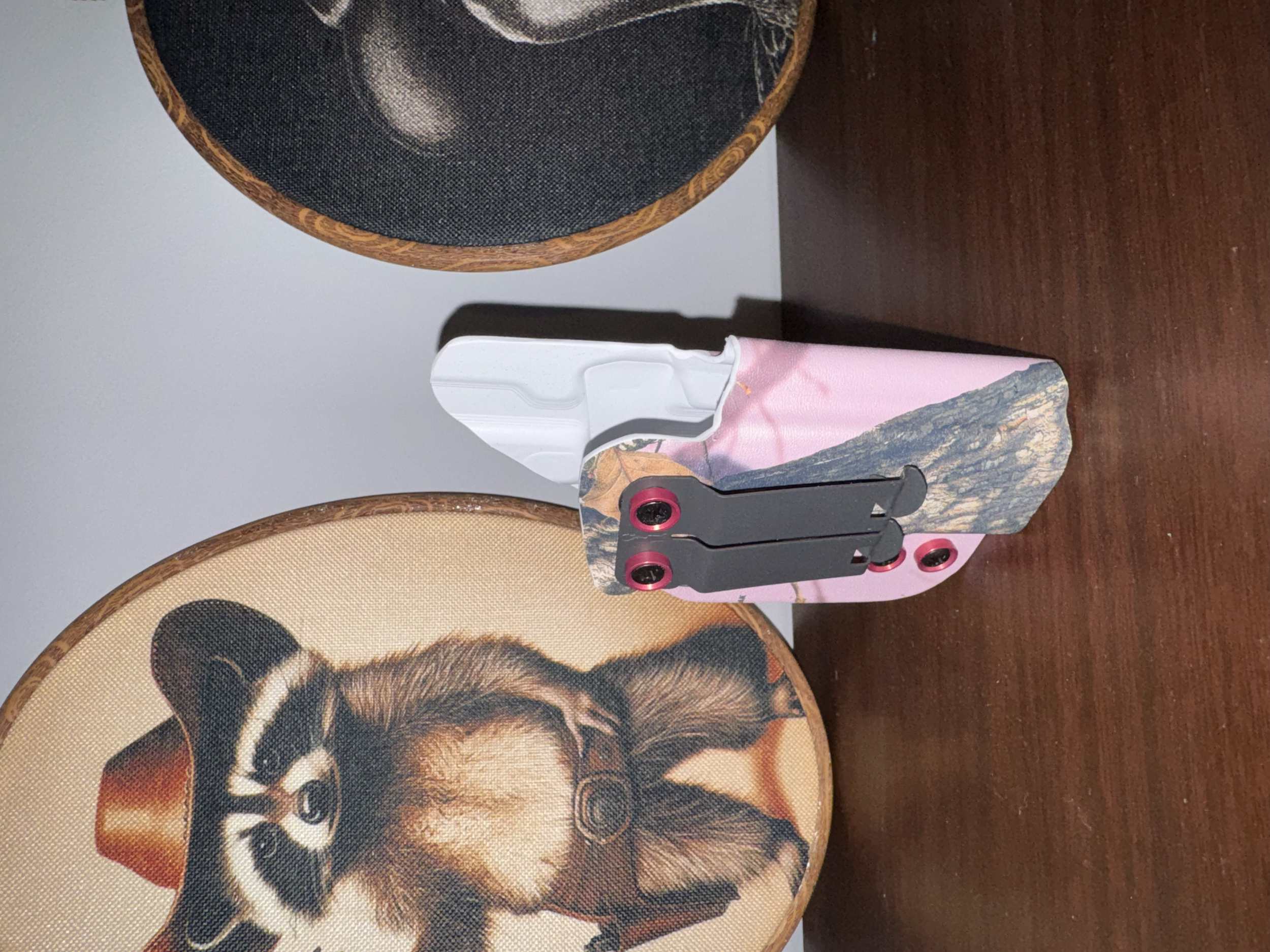 Close-up of a crossbody bag with a printed image of a woman's face, featuring detailed artwork and a colorful design, placed on a wooden surface.
