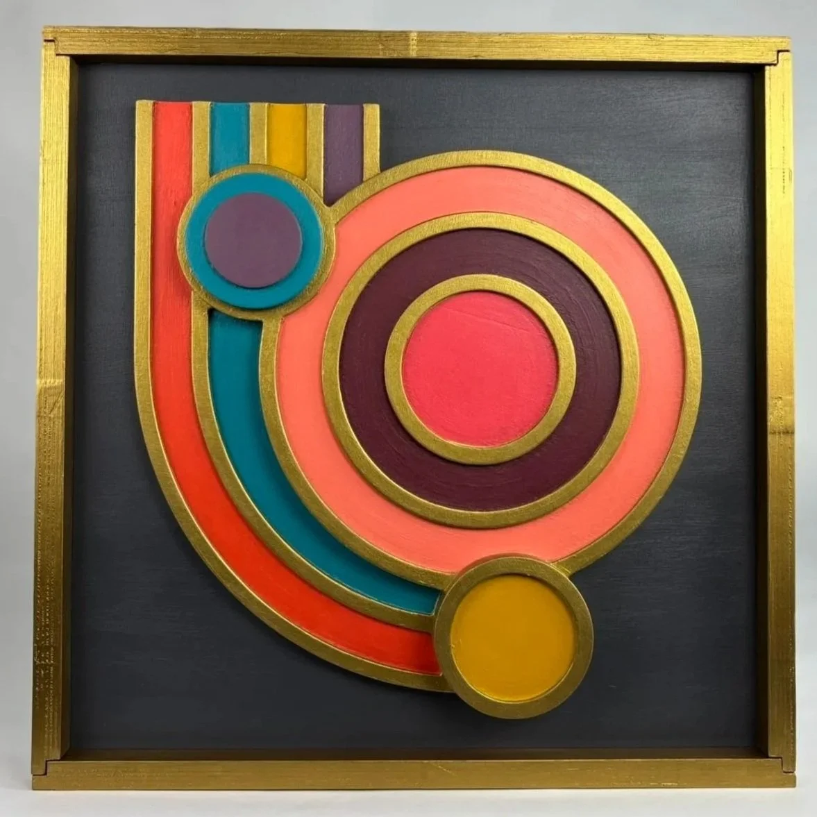 Colorful abstract geometric artwork with concentric circles and curved shapes in pink, purple, blue, red, and yellow, framed in gold.