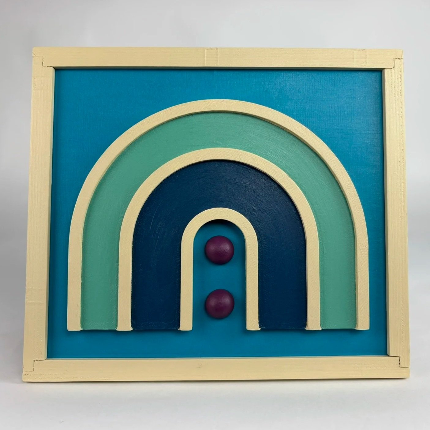 Colorful wooden labyrinth with two purple spheres inside, set against a light background.