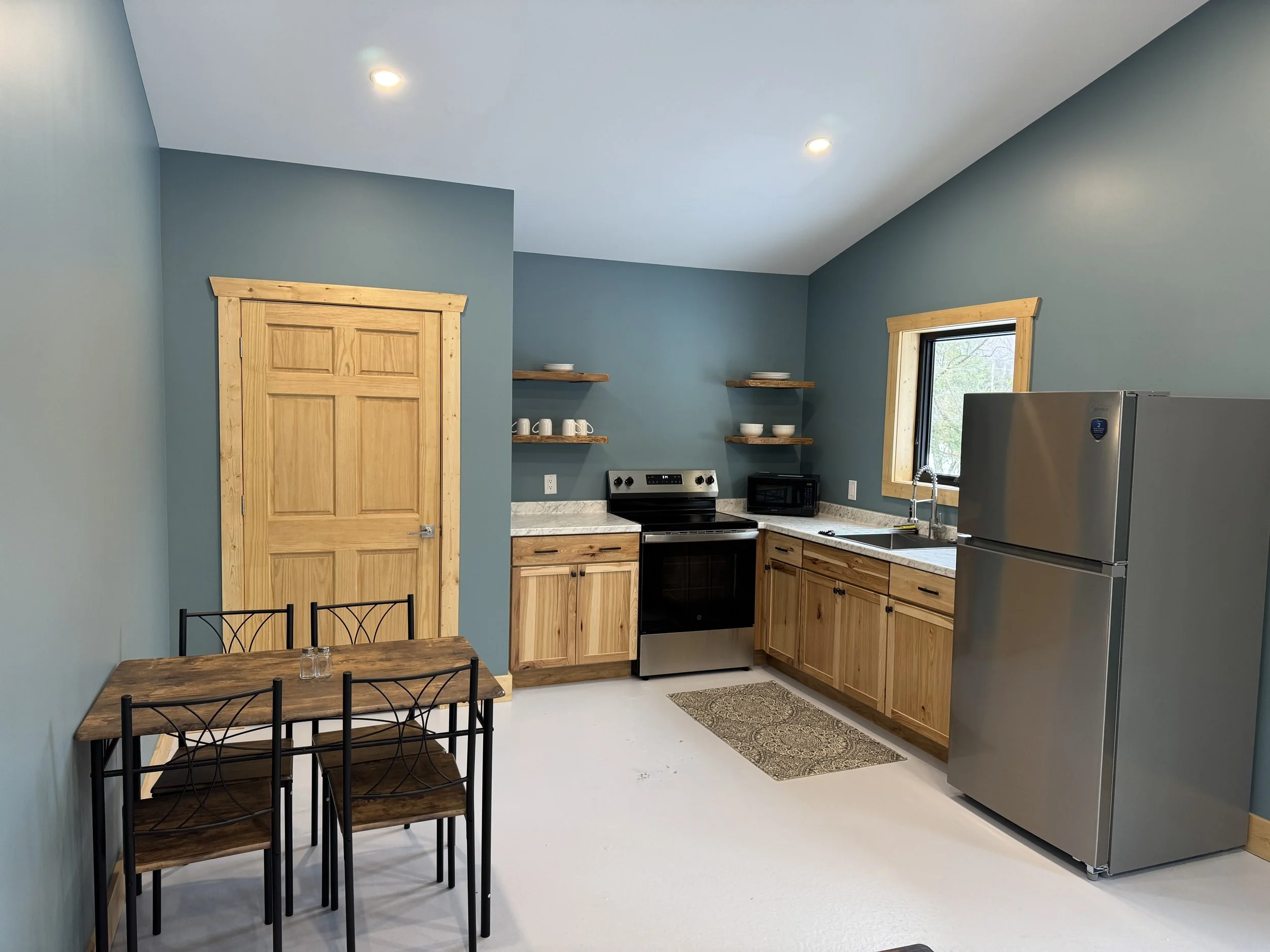 Fully equipped kitchen including stove, oven, and microwave along with cooking utensil necessities. 