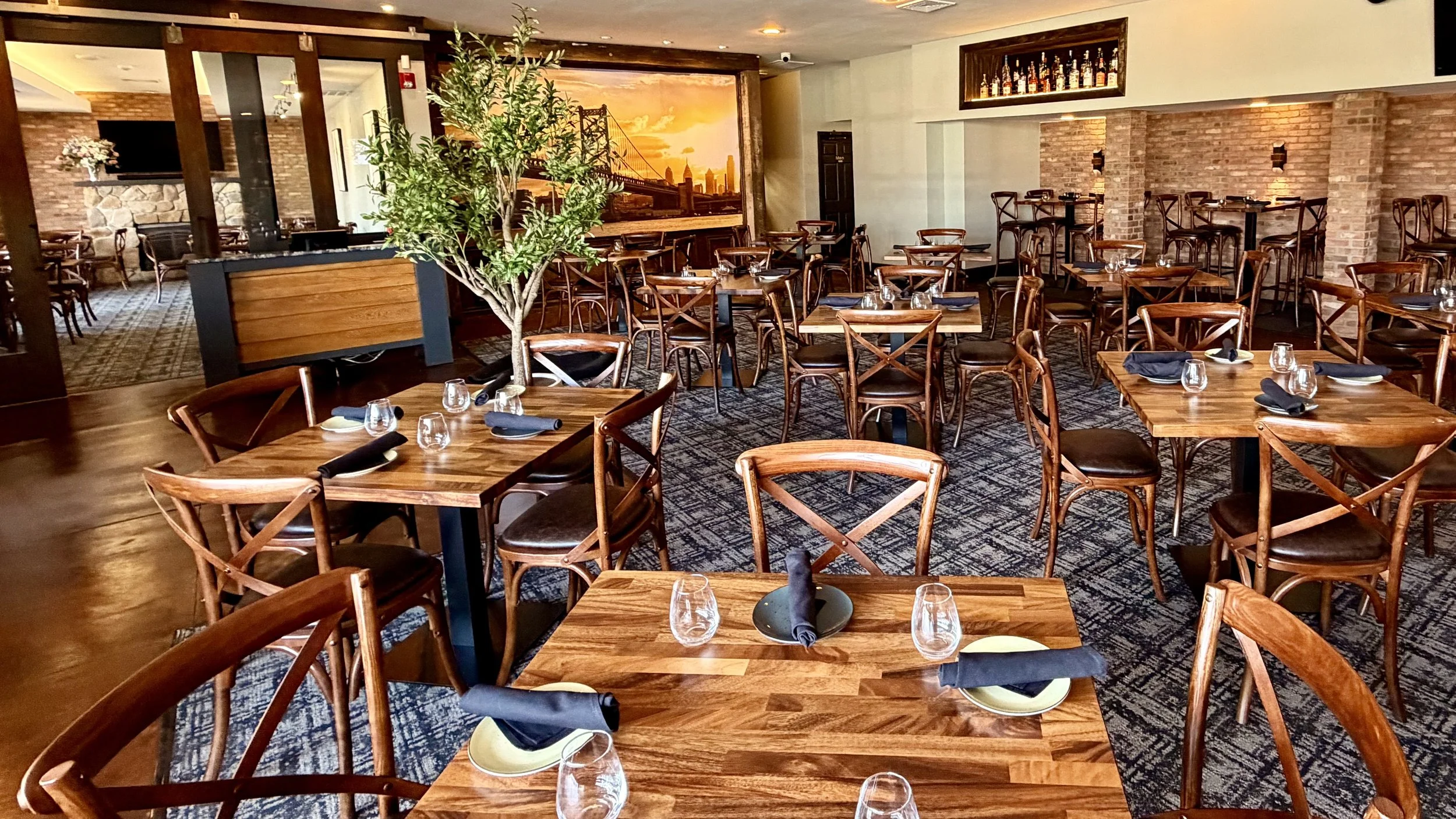 Main dining room at Duo Restaurant & Bar in Haddon Township, NJ – featuring Ben Franklin Bridge mural, wood tables, and warm ambiance