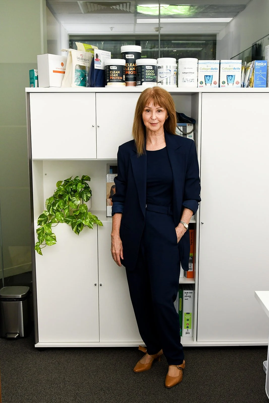Cheryl Penna in her Urban Sense Wellness clinic in Melbourne, surrounded by practitioner-grade supplements and natural health tools.