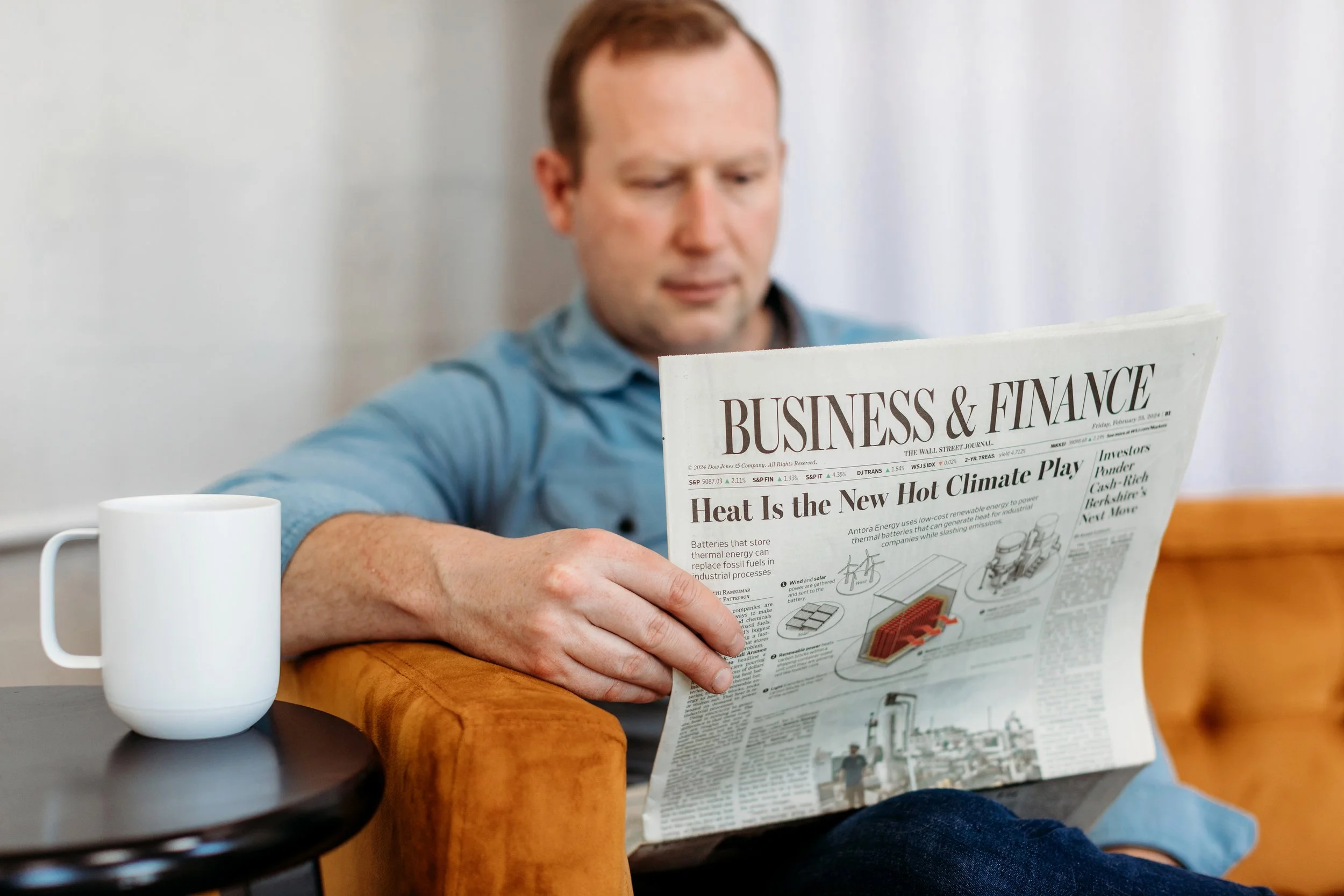 accountant man holding a New York Times newspaper and a coffee cup next to him