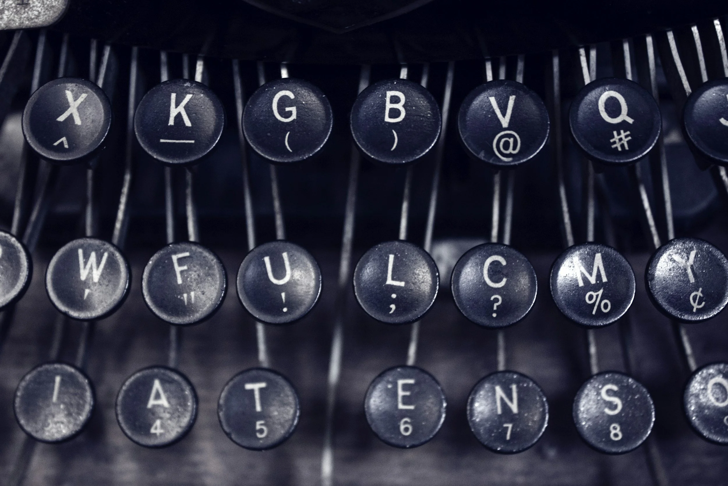 Close-up of vintage typewriter keys showing letters and symbols in black and white.