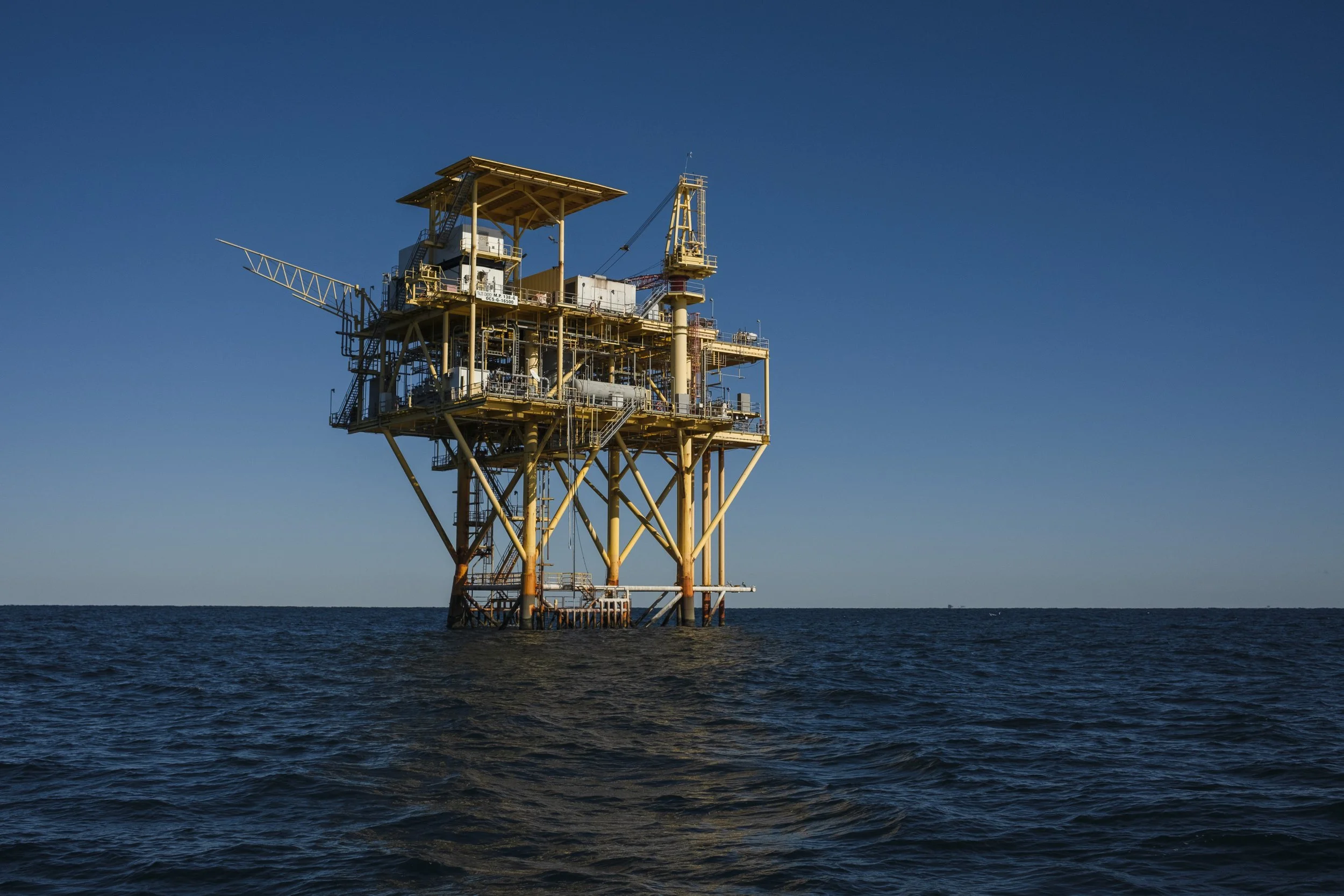 Offshore oil rig in the ocean with clear blue sky.