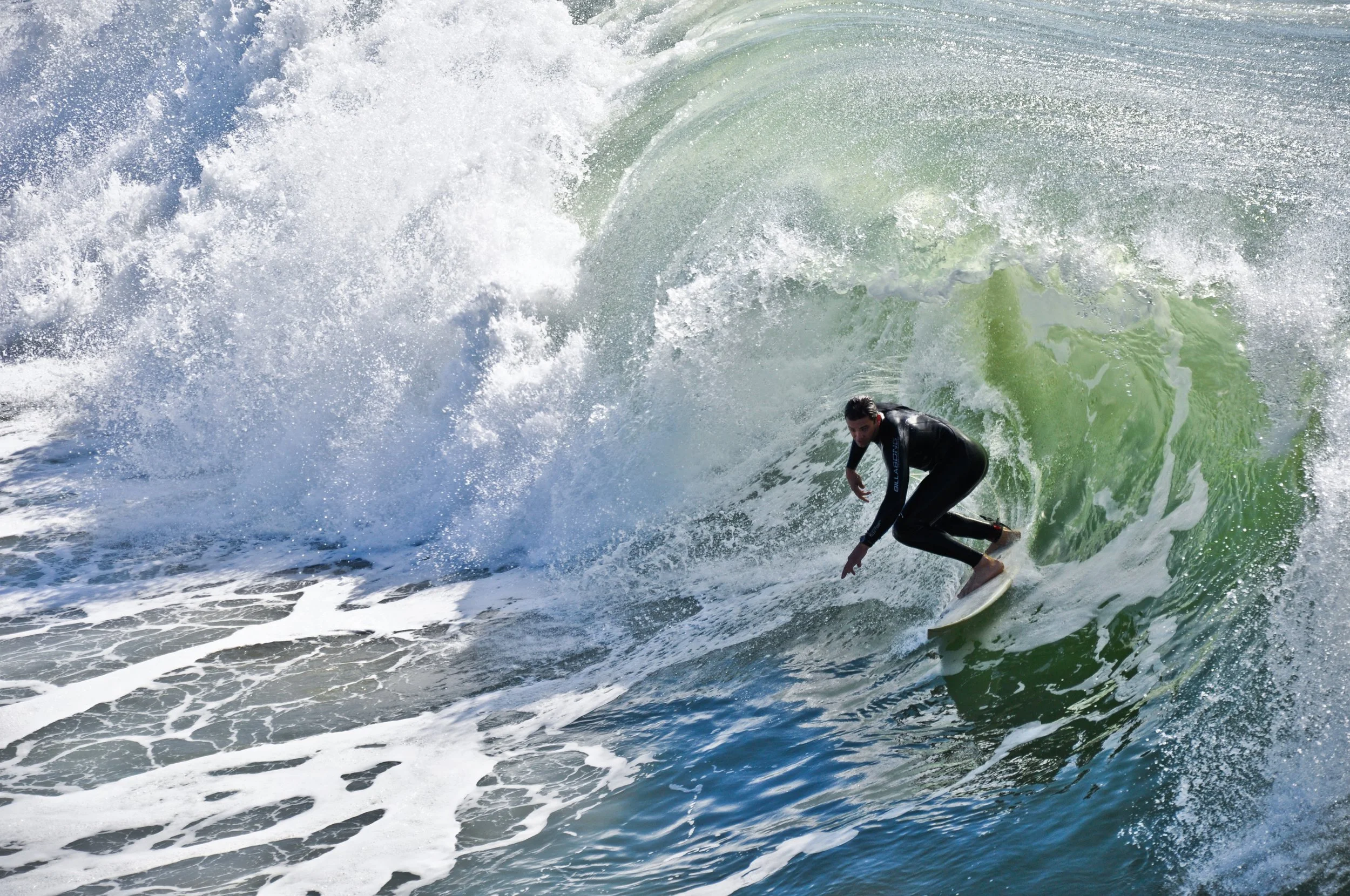 A person surfing on a large wave in the ocean.