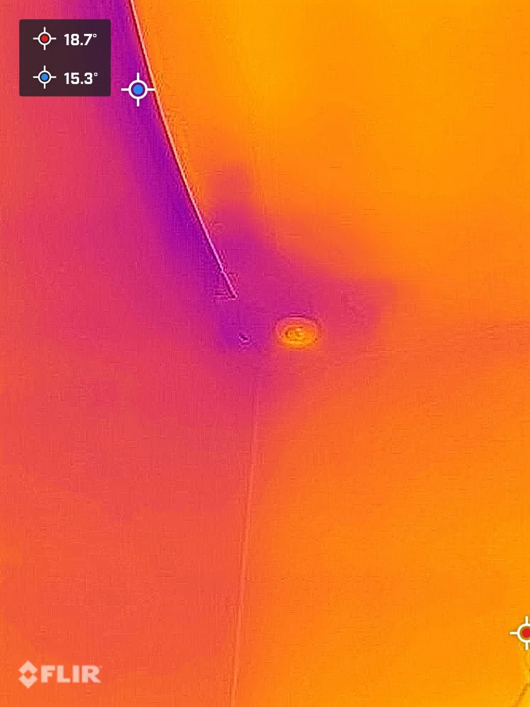 Infrared thermal image of a wall and ceiling showing two distinct temperature zones, with a temperature difference of about 3.4 degrees Celsius, highlighting potential heat loss or insulation issues around the electrical outlet and ceiling corner.