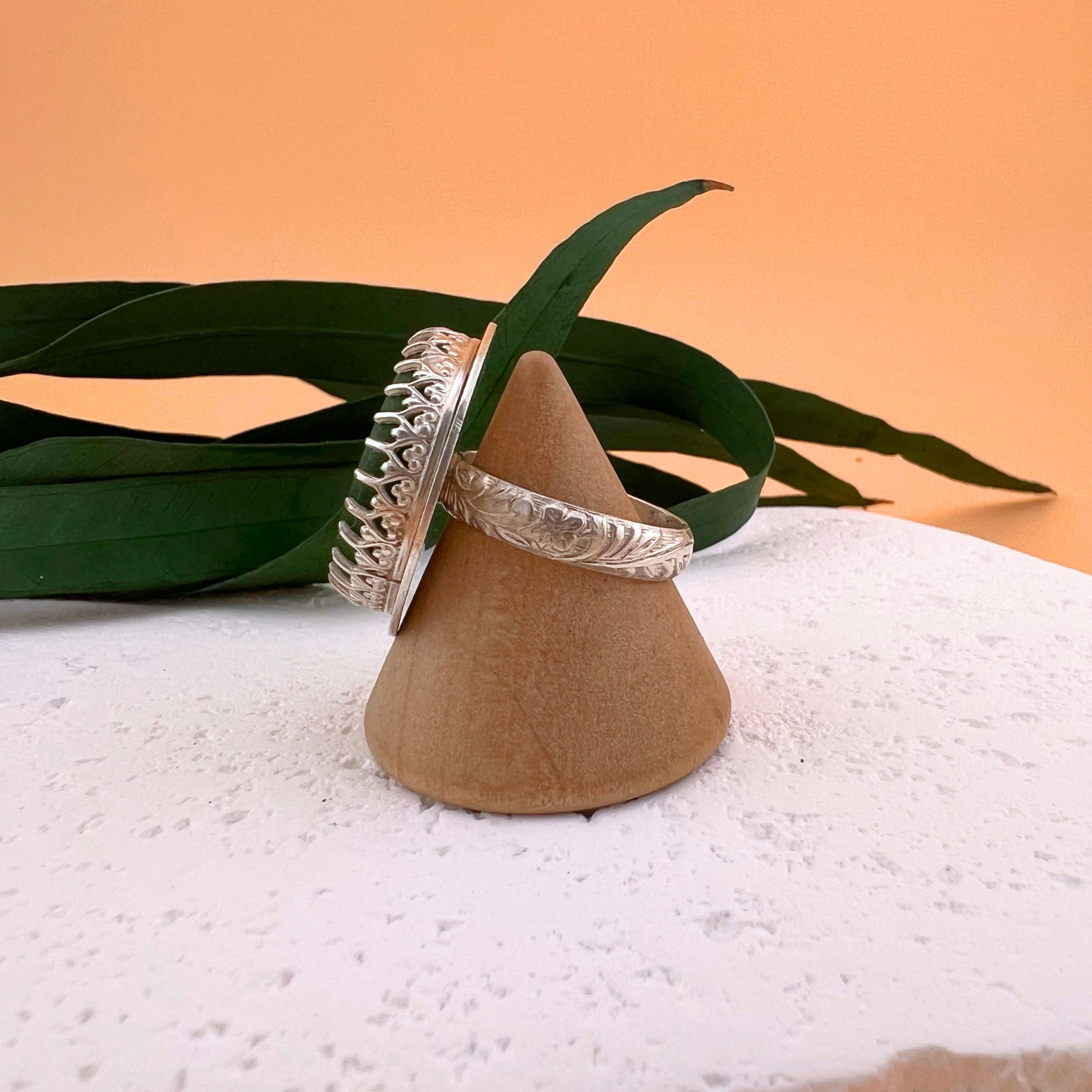 Side view of a bright green sea glass ring showing the sterling silver setting and the thickness of the sea glass.