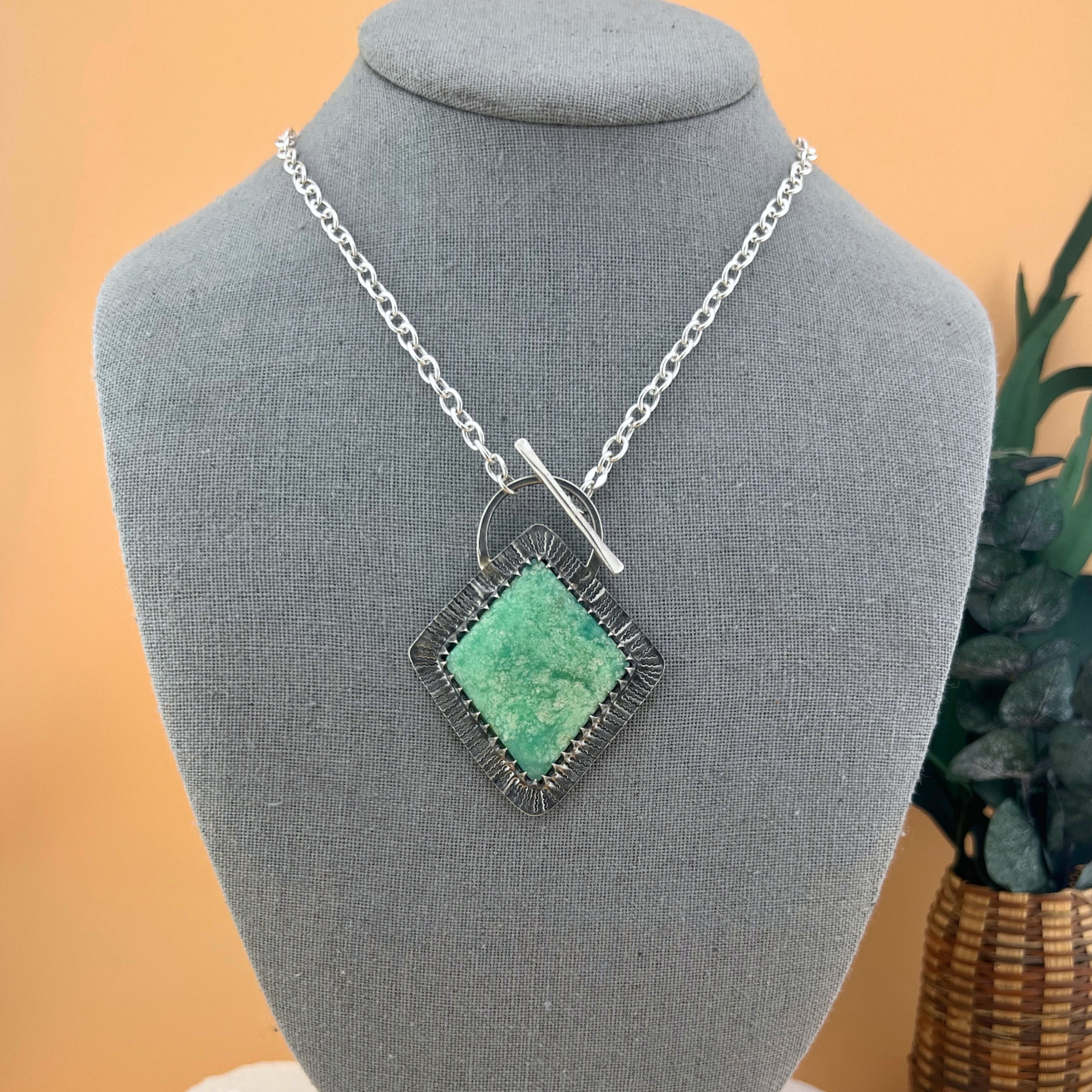 Sterling silver chrysoprase statement necklace with front toggle clasp and cable chain displayed on a jewelry bust for scale.