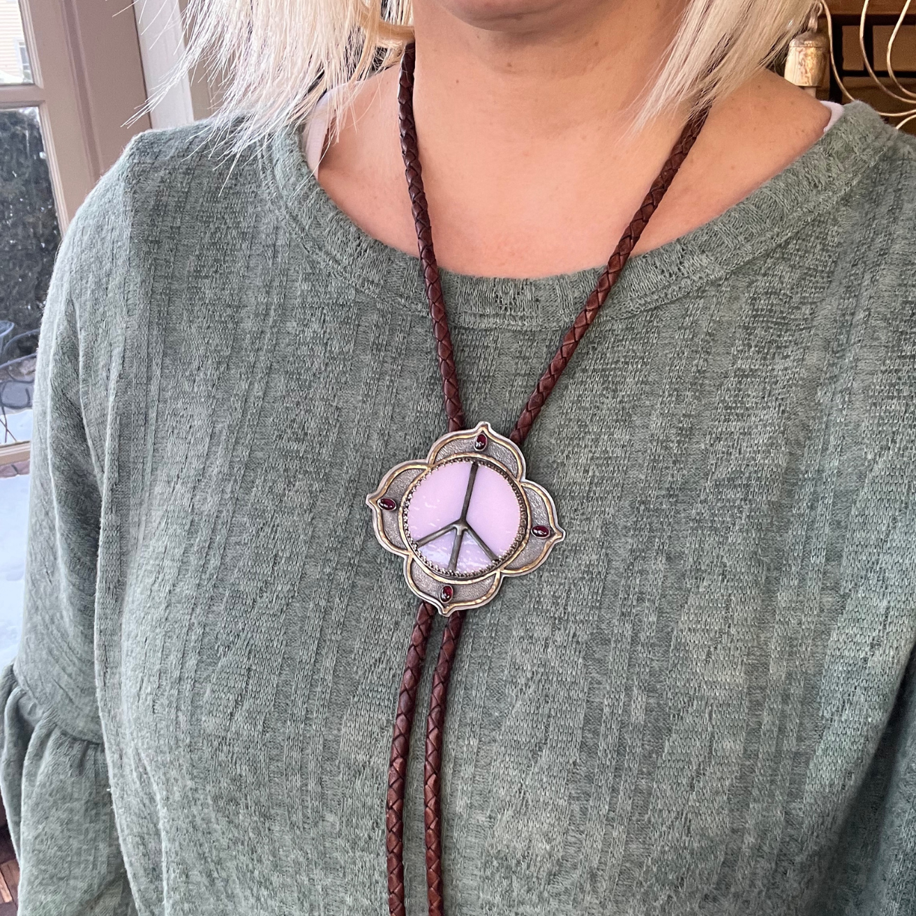 Lavender stained glass Peace Portal bolo tie accented with grape garnet gemstones, shown worn for expressive, artistic styling.
