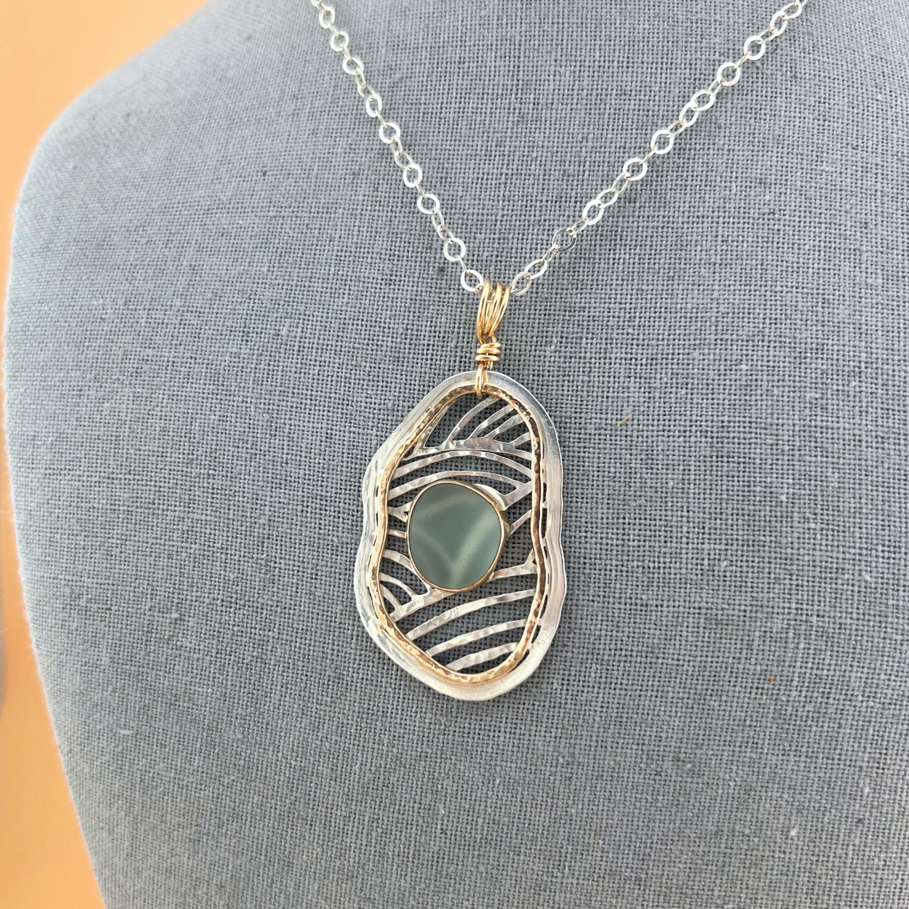 Handmade silver and gold fill sea glass necklace displayed on a neutral bust.