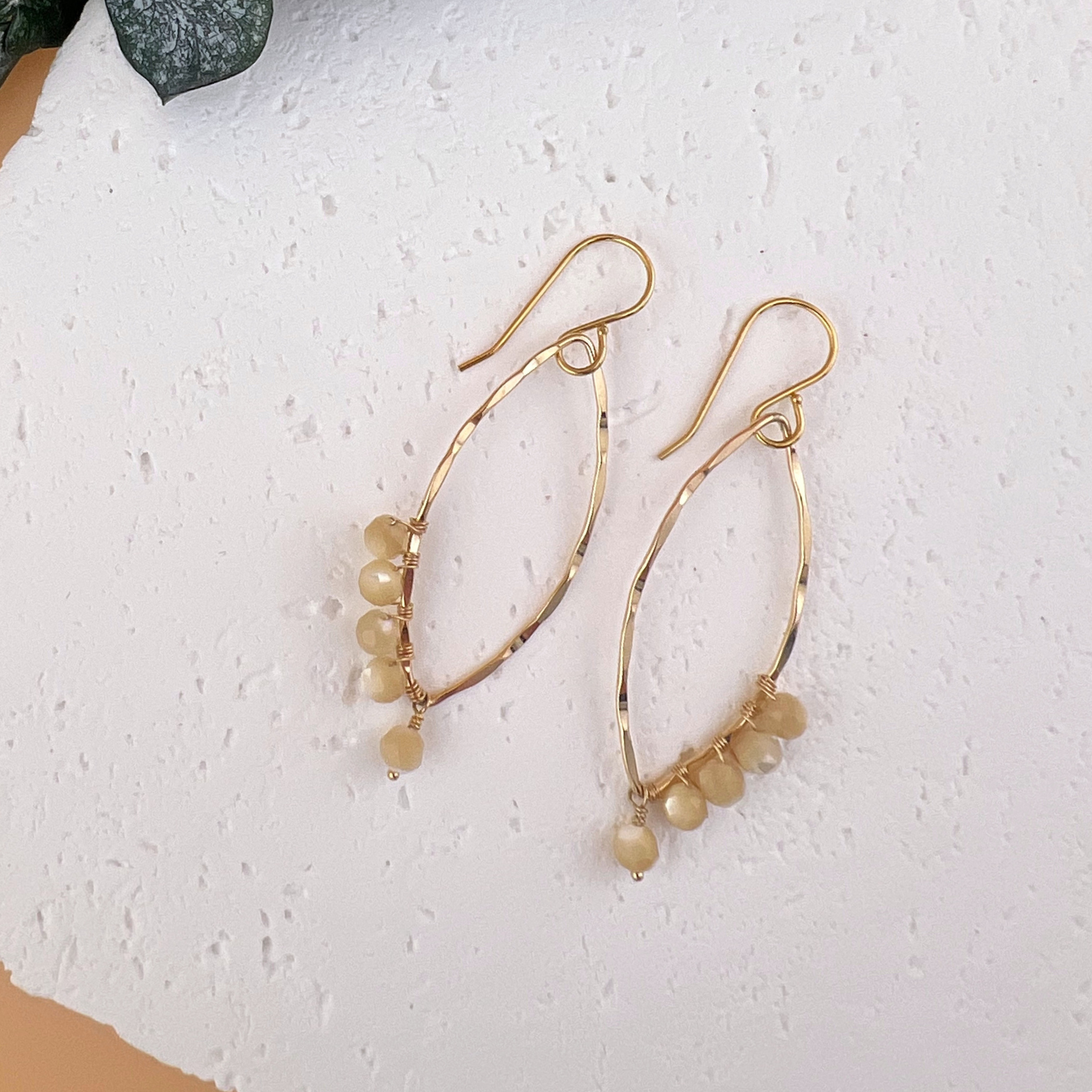 Handmade 14kt gold fill dangle earrings with hammered petal-shaped drops and hand-wrapped mother of pearl beads.
