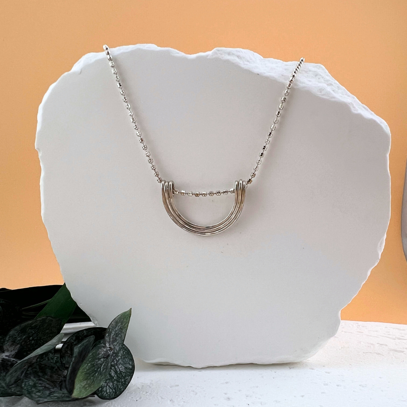 Sterling silver Simplicity Arc necklace with curved minimalist pendant.