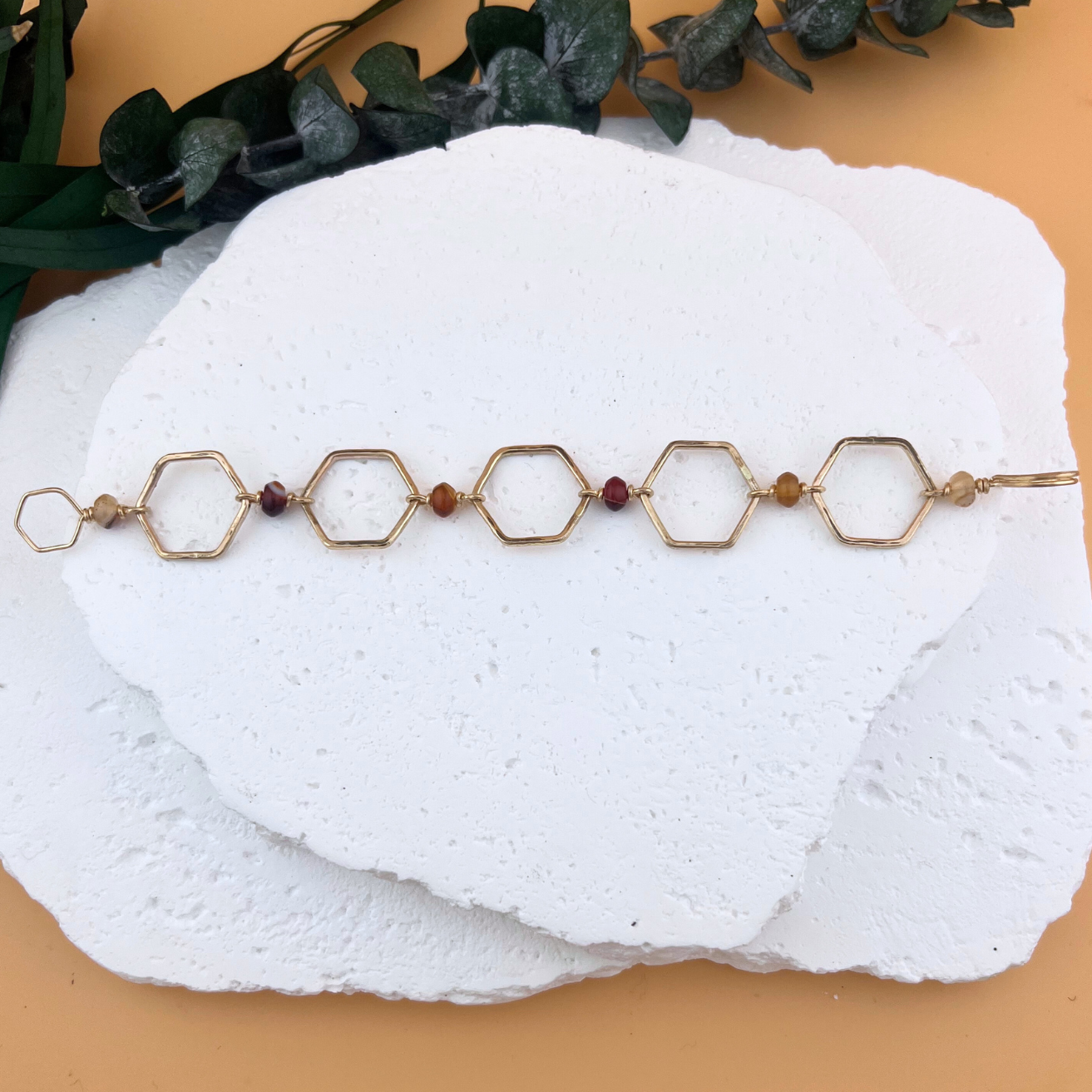 Handcrafted hexagon link bracelet with red banded agate beads in gold fill.