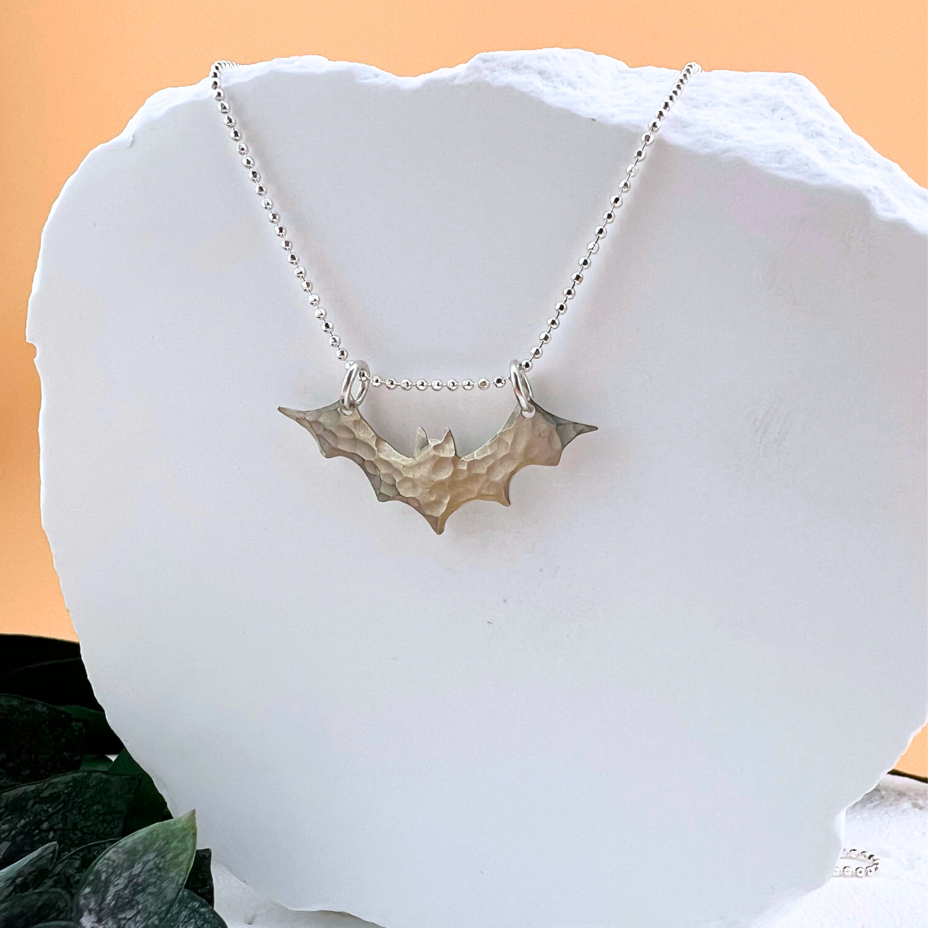 Handcrafted sterling silver eclipse style bat necklace with hammered texture.