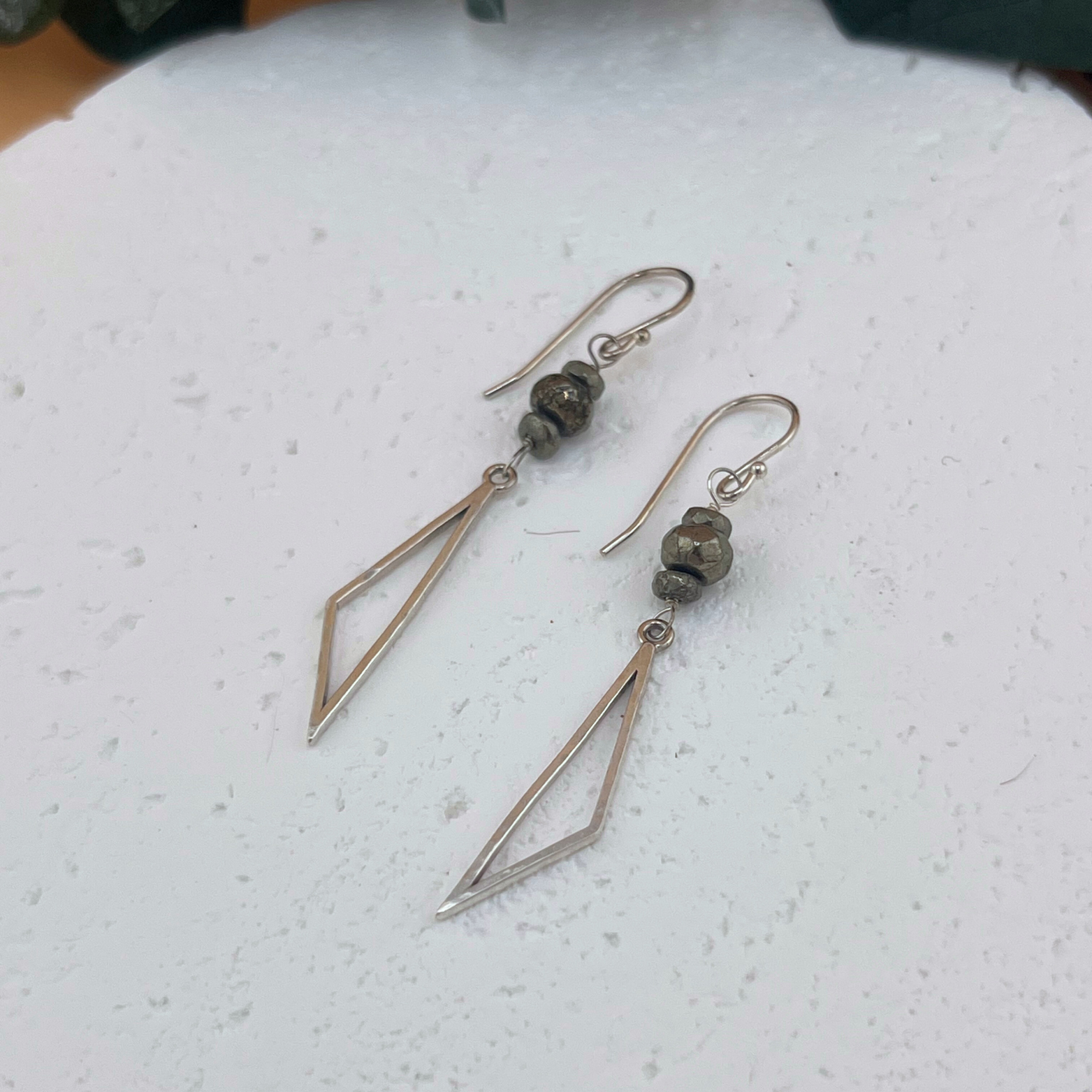 Handmade sterling silver drop earrings with hammered triangular shapes and faceted pyrite bead accents.