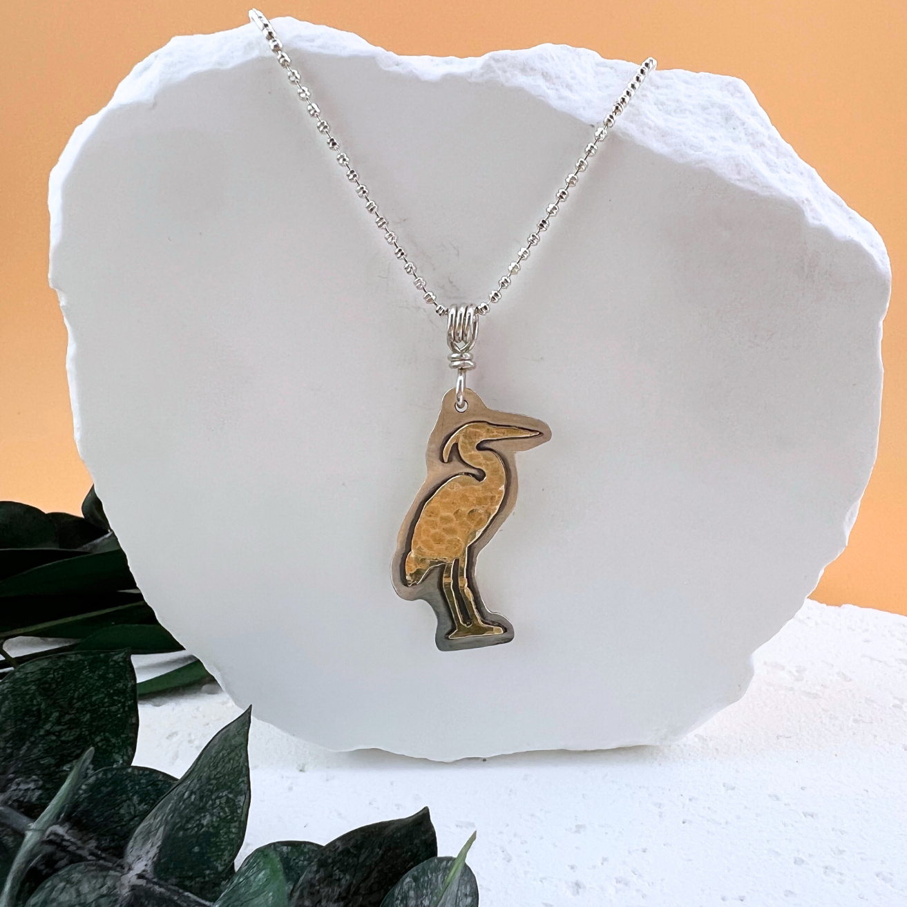 Heritage Heron necklace in brass and sterling silver.