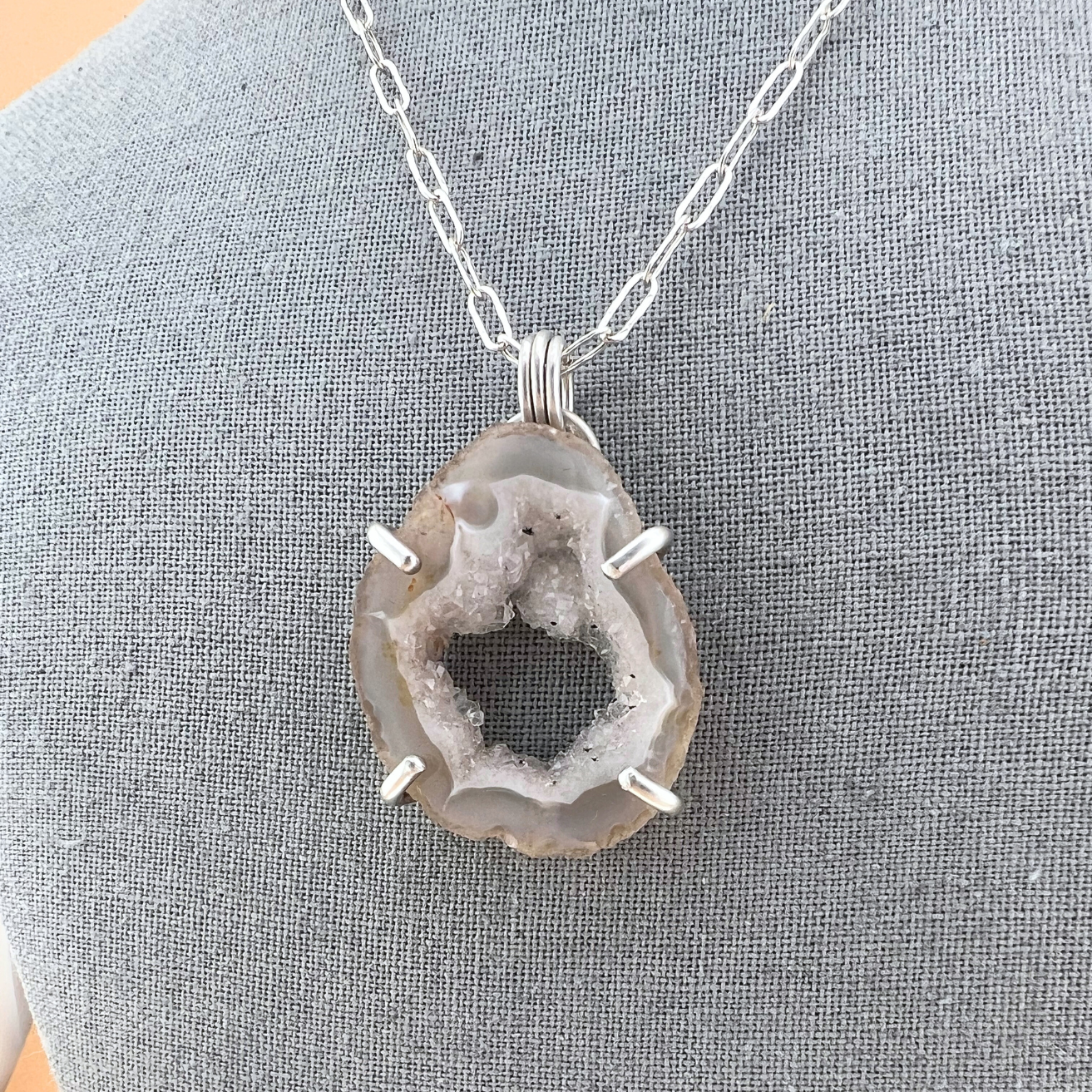 Natural agate geode pendant necklace featuring raw crystalline interior.