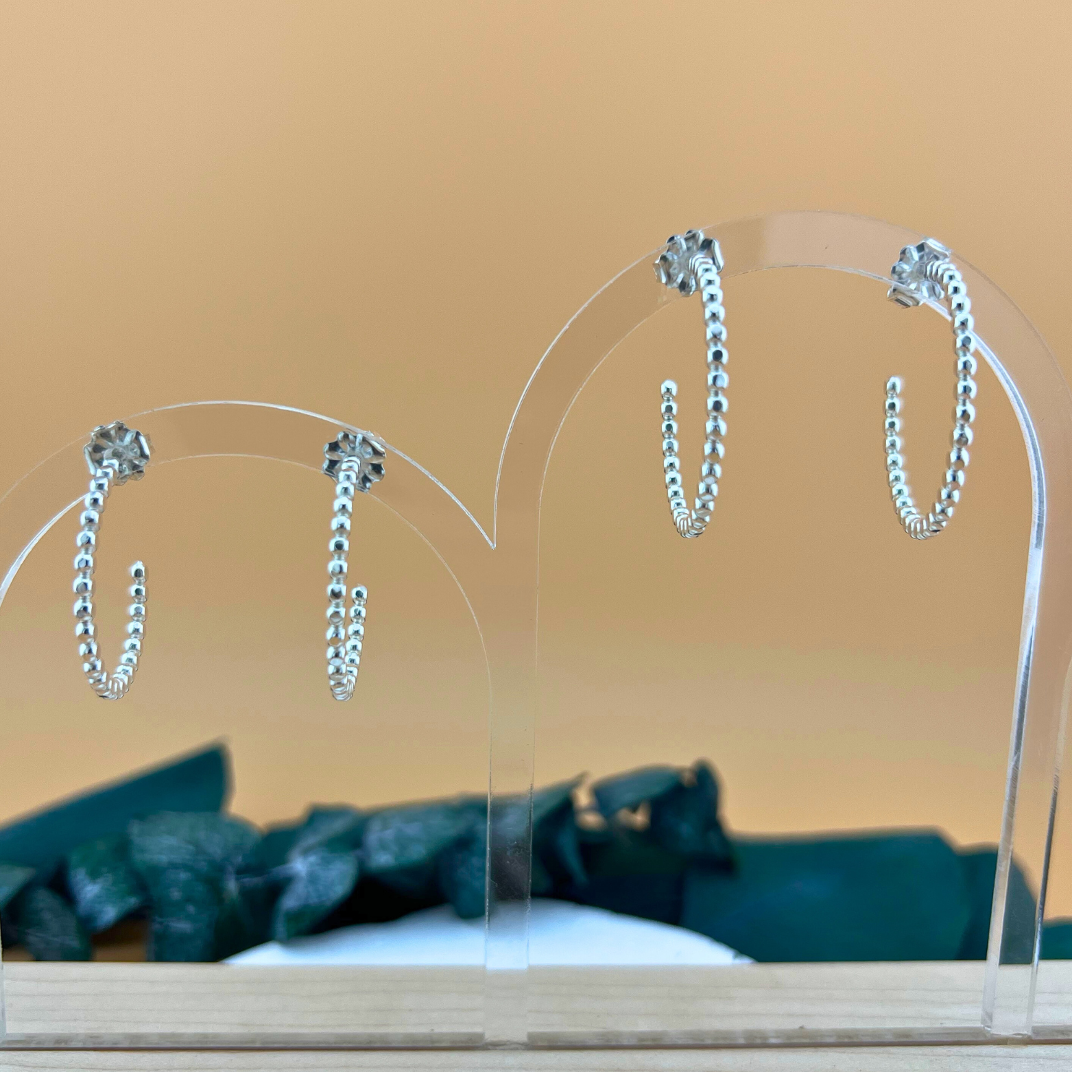 Sterling silver post hoop earrings made from beaded wire, lightly hammered to reflect light, shown in small and large sizes.