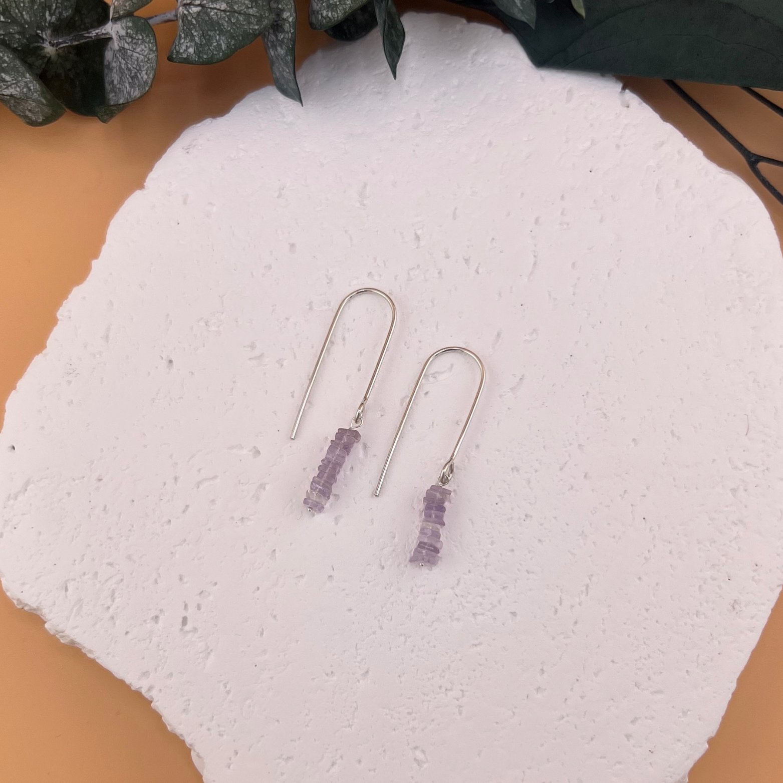 Handmade sterling silver threader earrings with faceted amethyst bead drops in a minimal vertical design.