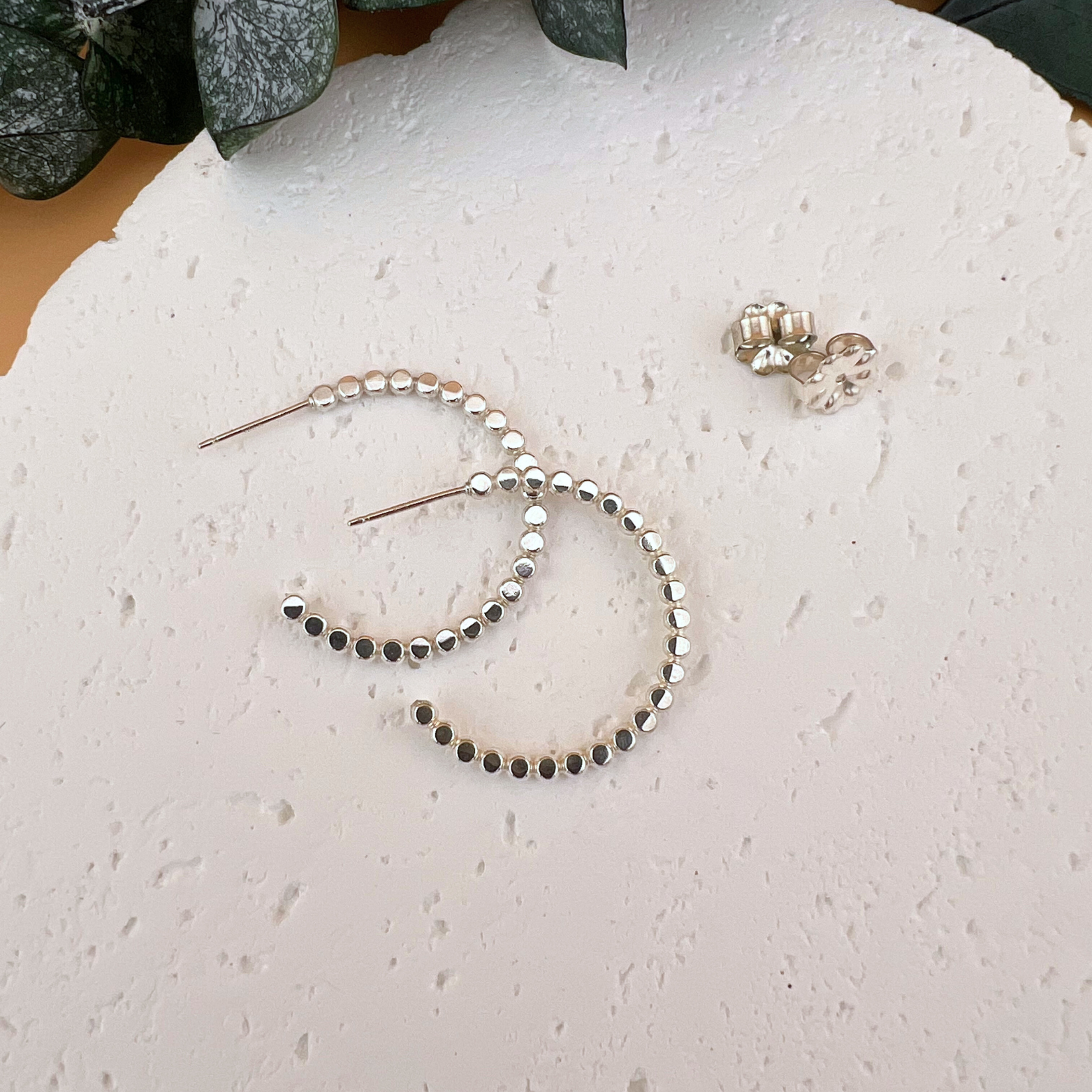 Sterling silver post hoop earrings made from beaded wire, lightly hammered to reflect light, shown in  small- 3/4" diameter.