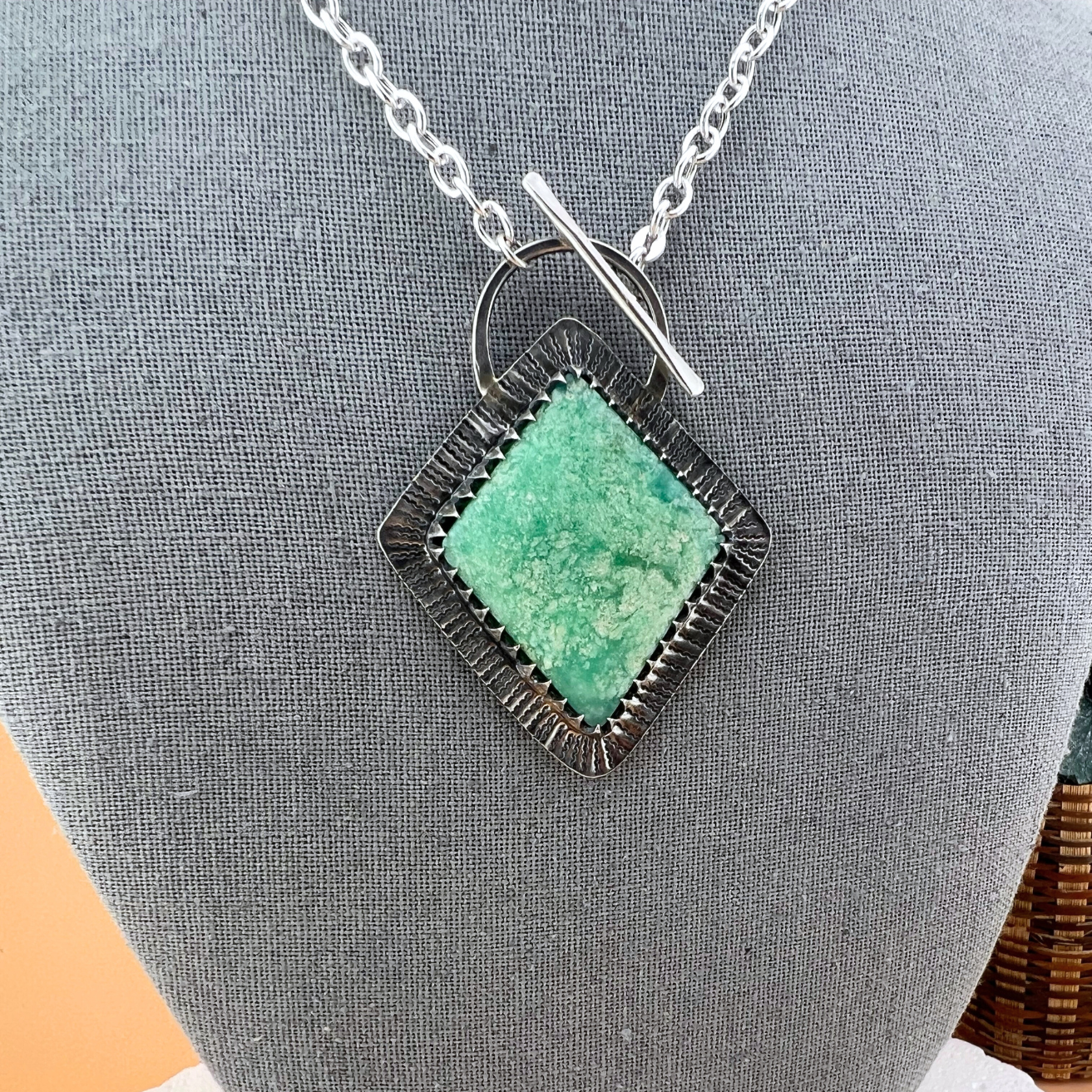 Close-up of natural chrysoprase stone set in textured sterling silver bezel.