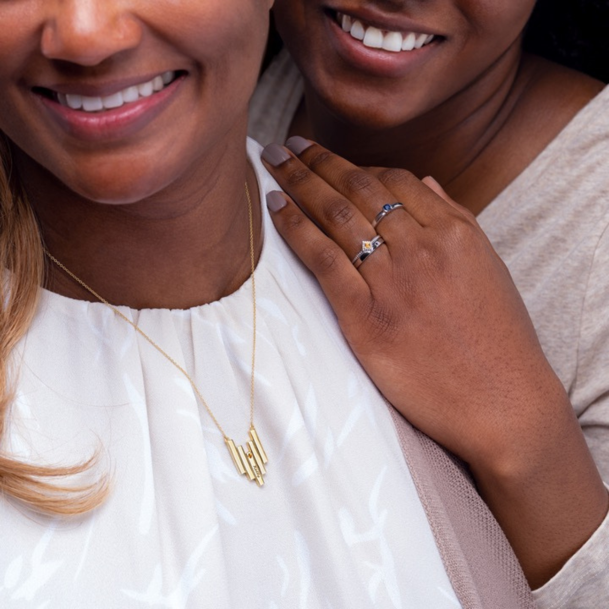 woman adorned in custom deco inspired initial and birthstone necklace.