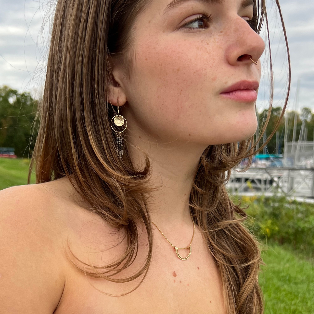 Woman wearing the gold fill Simplicity Arc necklace on a delicate chain.