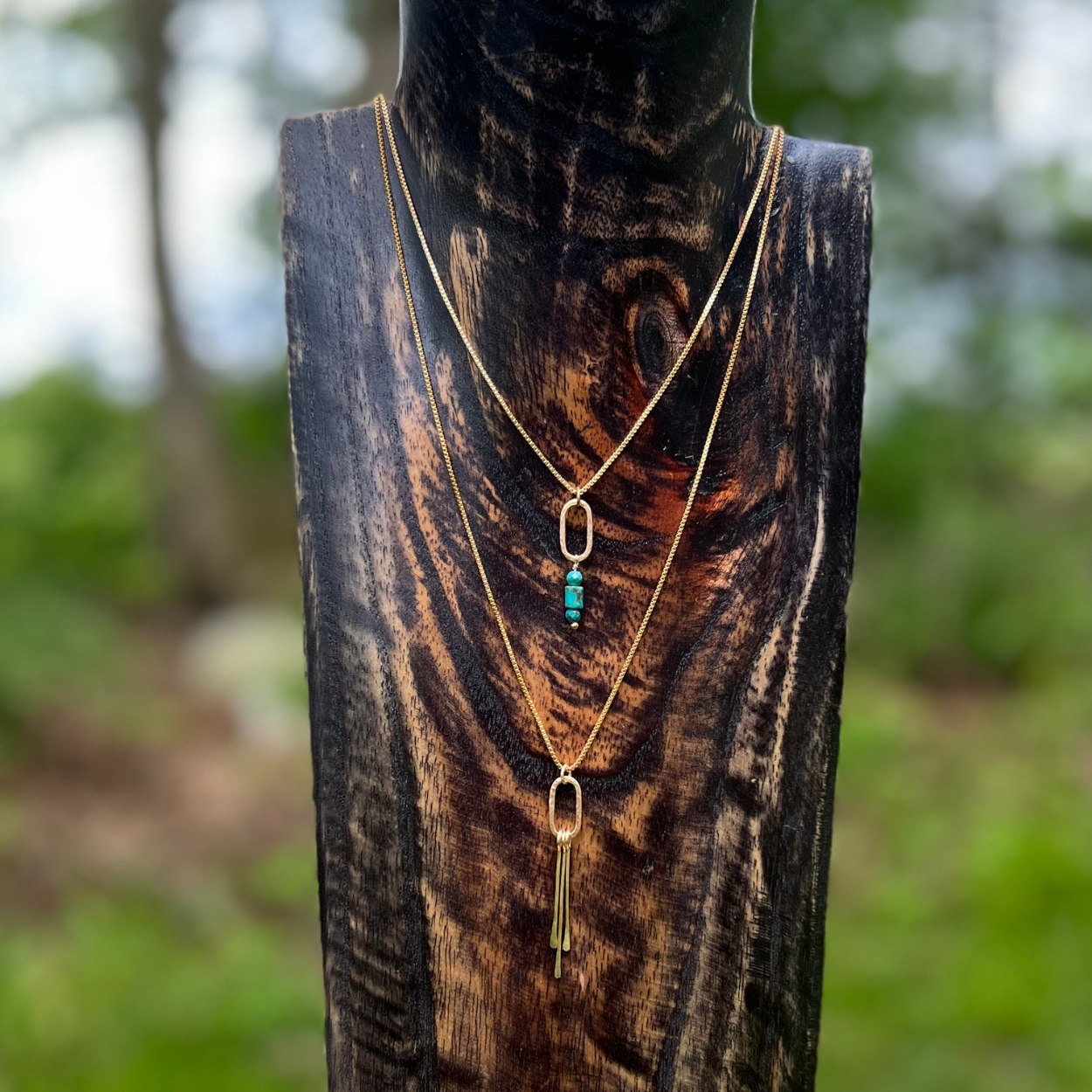Anchor + Sky Necklace in 14kt gold fill featuring a hammered oval link with Kingman turquoise beads, displayed on a wooden bust and layered with the original Fringe elements necklace.