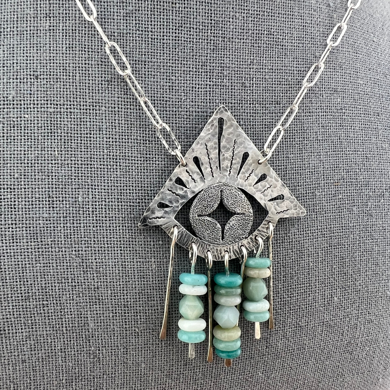 Close-up of sterling silver eye pendant with textured detailing and amazonite beads, part of the Mystic Collection.