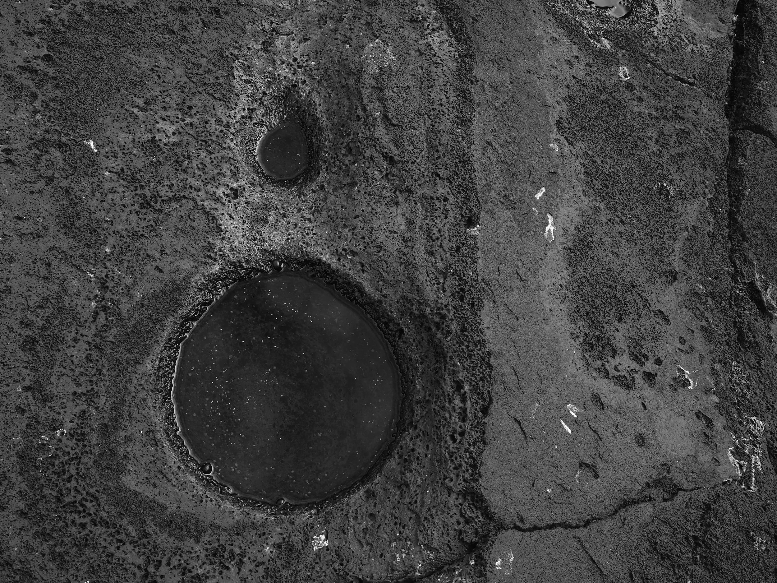 ancient holes and rock in hawaii black and white