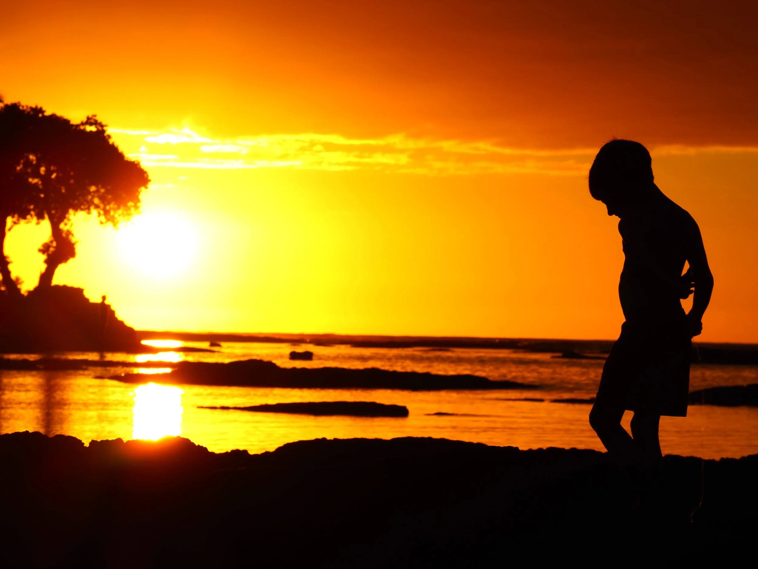 boy on beach at sunset in Hawaii