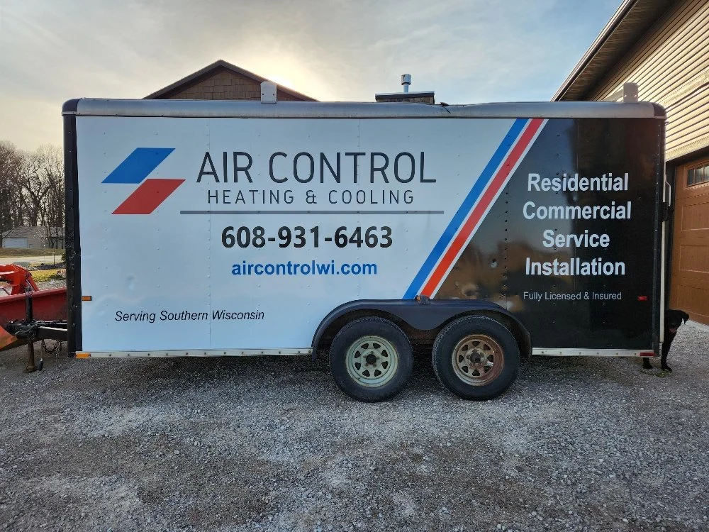 A trailer advertising Air Control Heating & Cooling, a business providing residential and commercial HVAC installation services in southern Wisconsin. The trailer displays the company name, phone number, website, and service details.