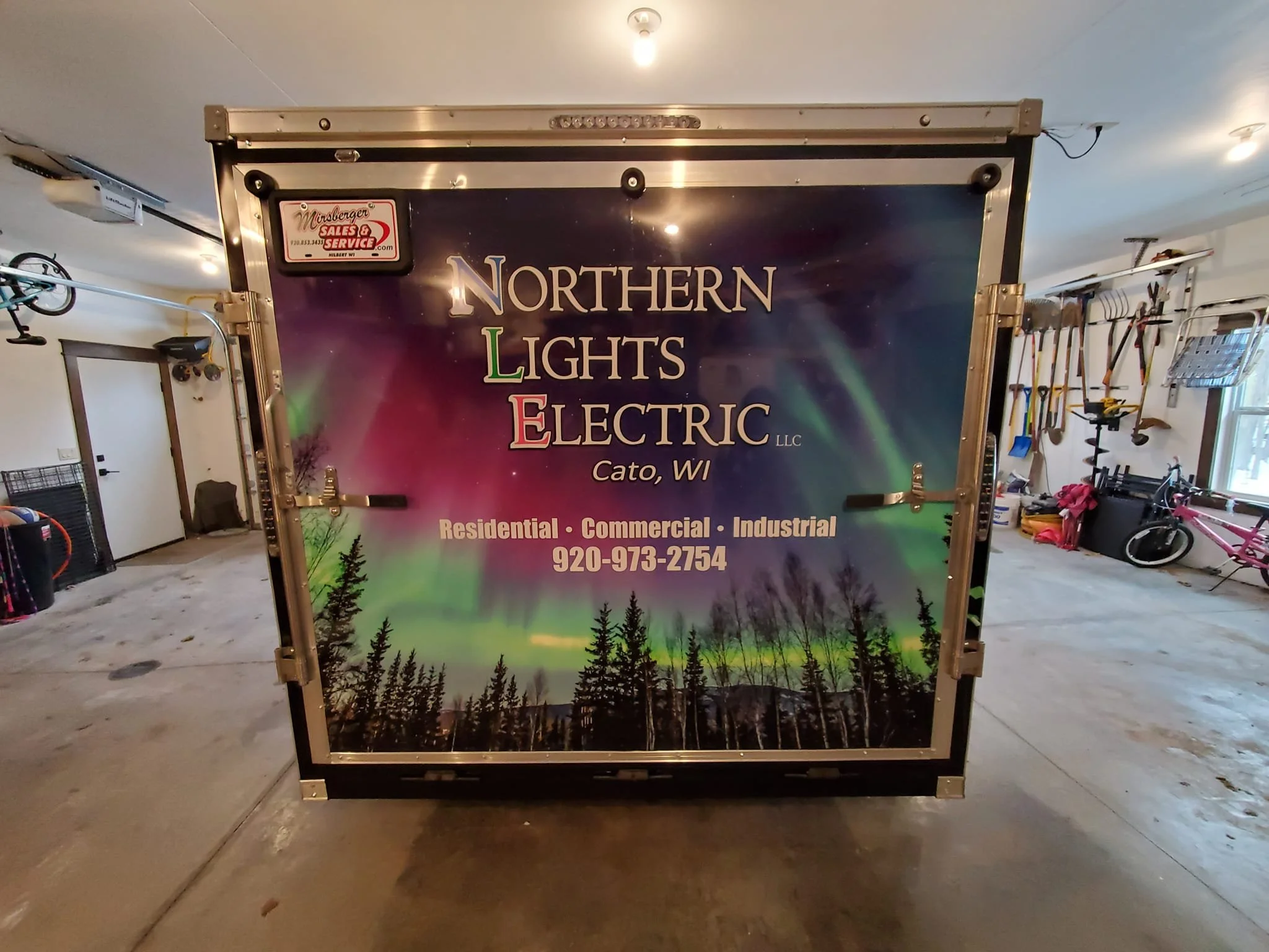 A promotional banner for Northern Lights Electric LLC featuring an image of the Northern Lights over a forest, with contact information and service areas listed.